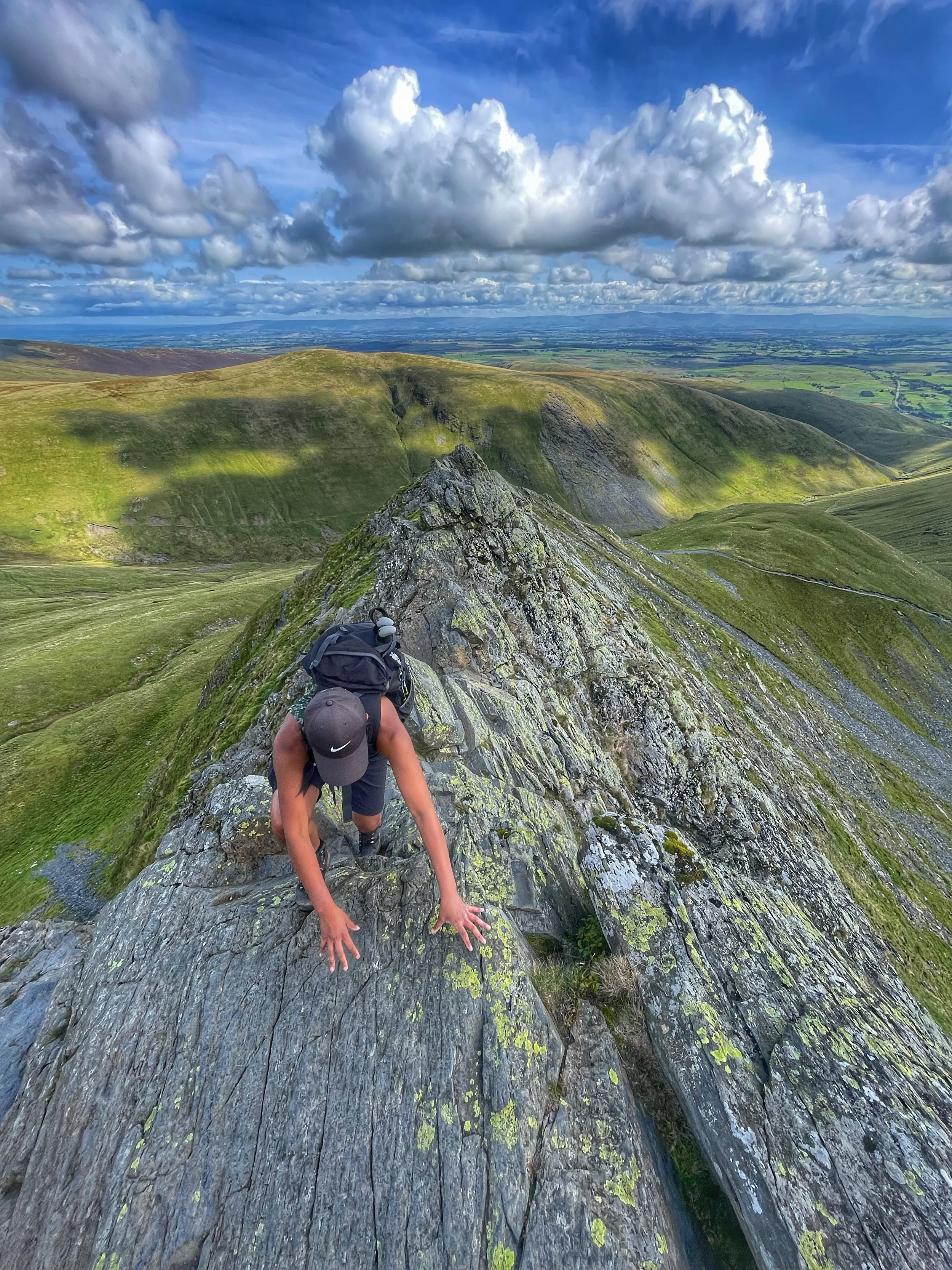 Climber carefully negotiating Bad Step on Sharp Edge Blencathera