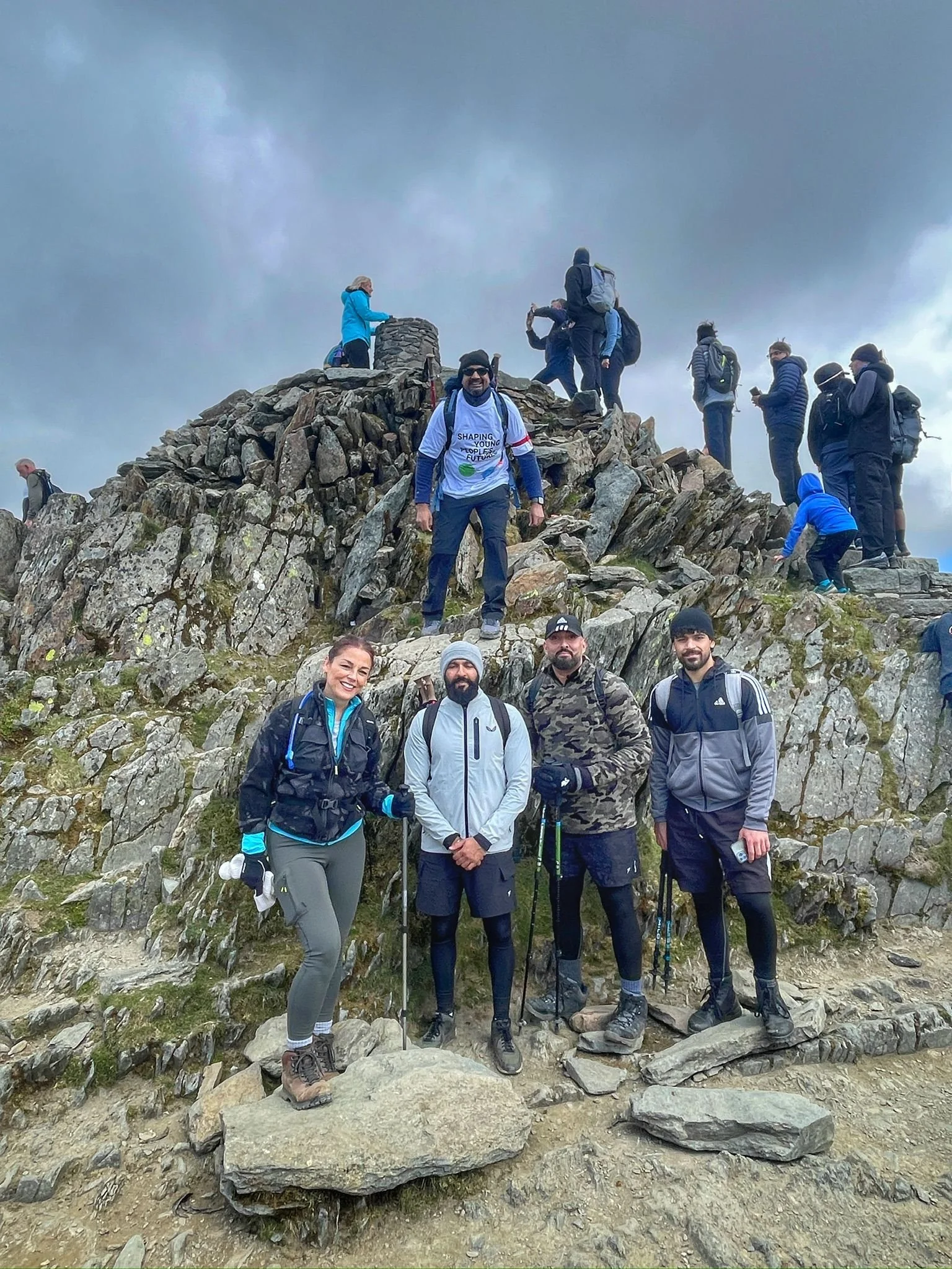 hikers on the summit of yr wyddfa during the snowdon horseshoe