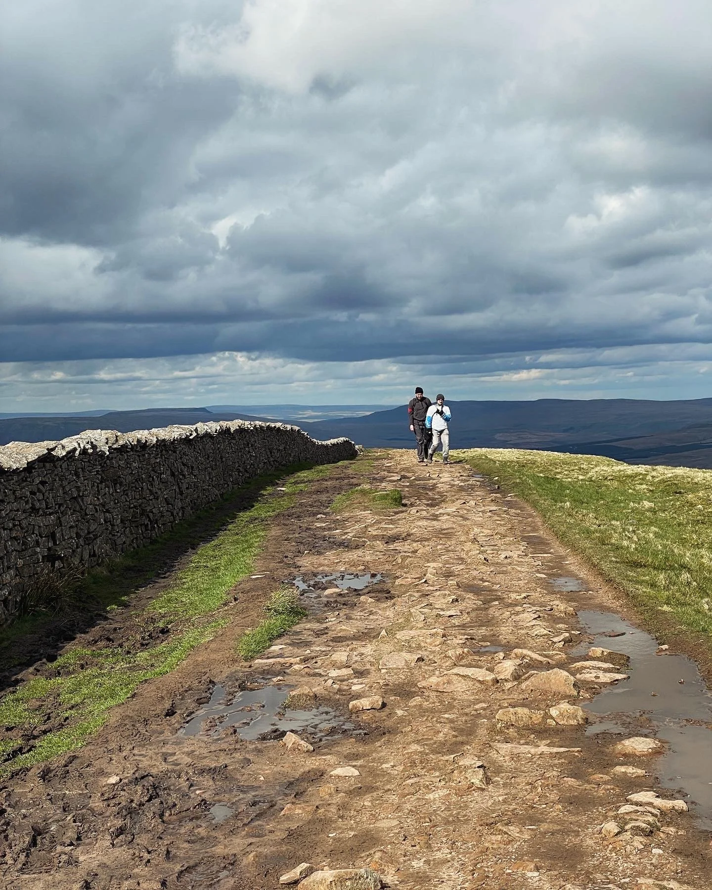 Hikers walking near the summit of whernside on the yorkshire three peaks challenge with yonder adventure company