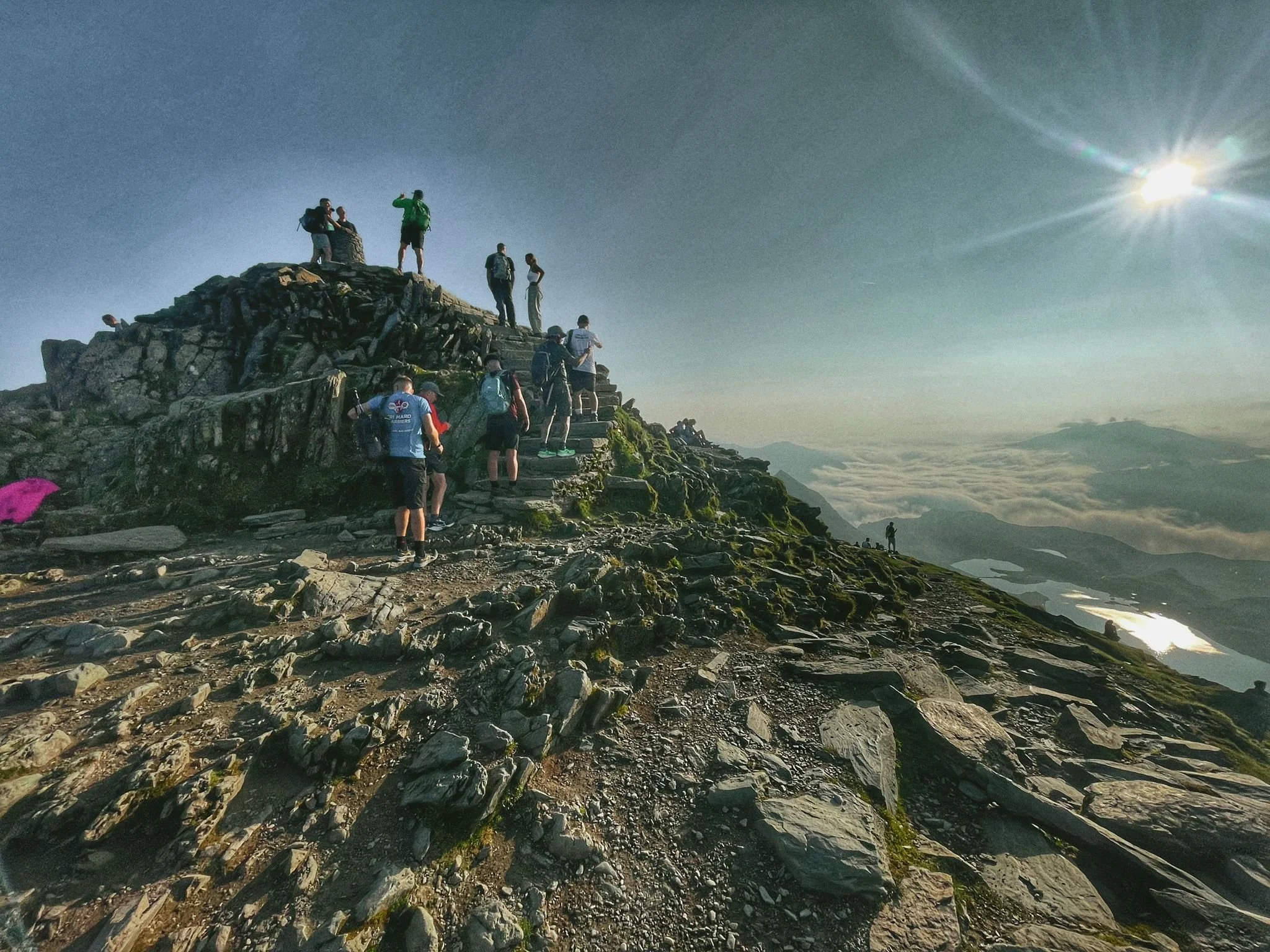hikers on the summit of yr wyddfa during the snowdon horseshoe