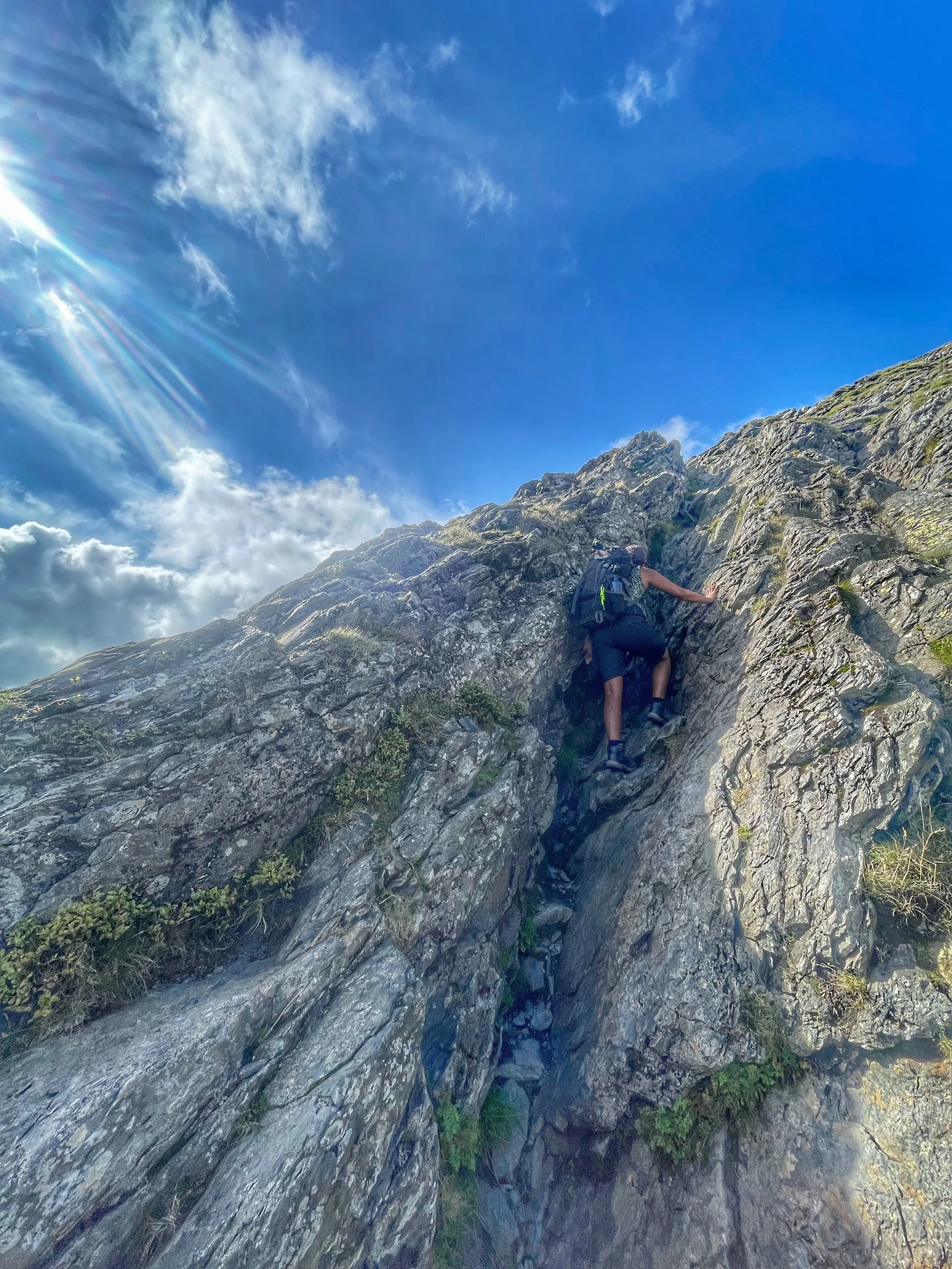 climber scrambling up to blencathra from sharp edge