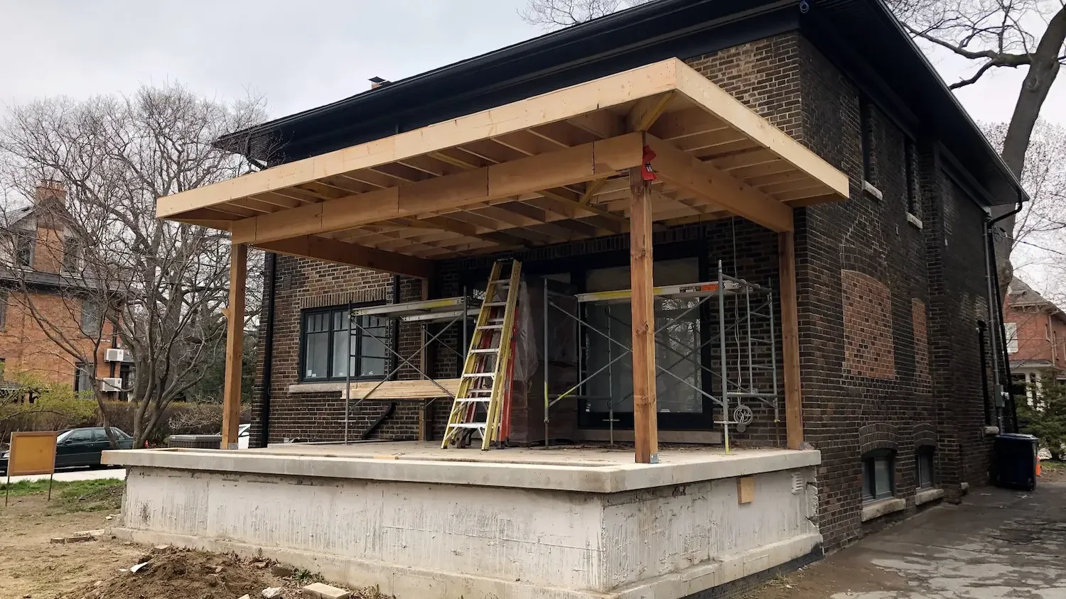 Covered patio roof framing with post and beam structure in Roncesvalles, Toronto by Odin Agnuk