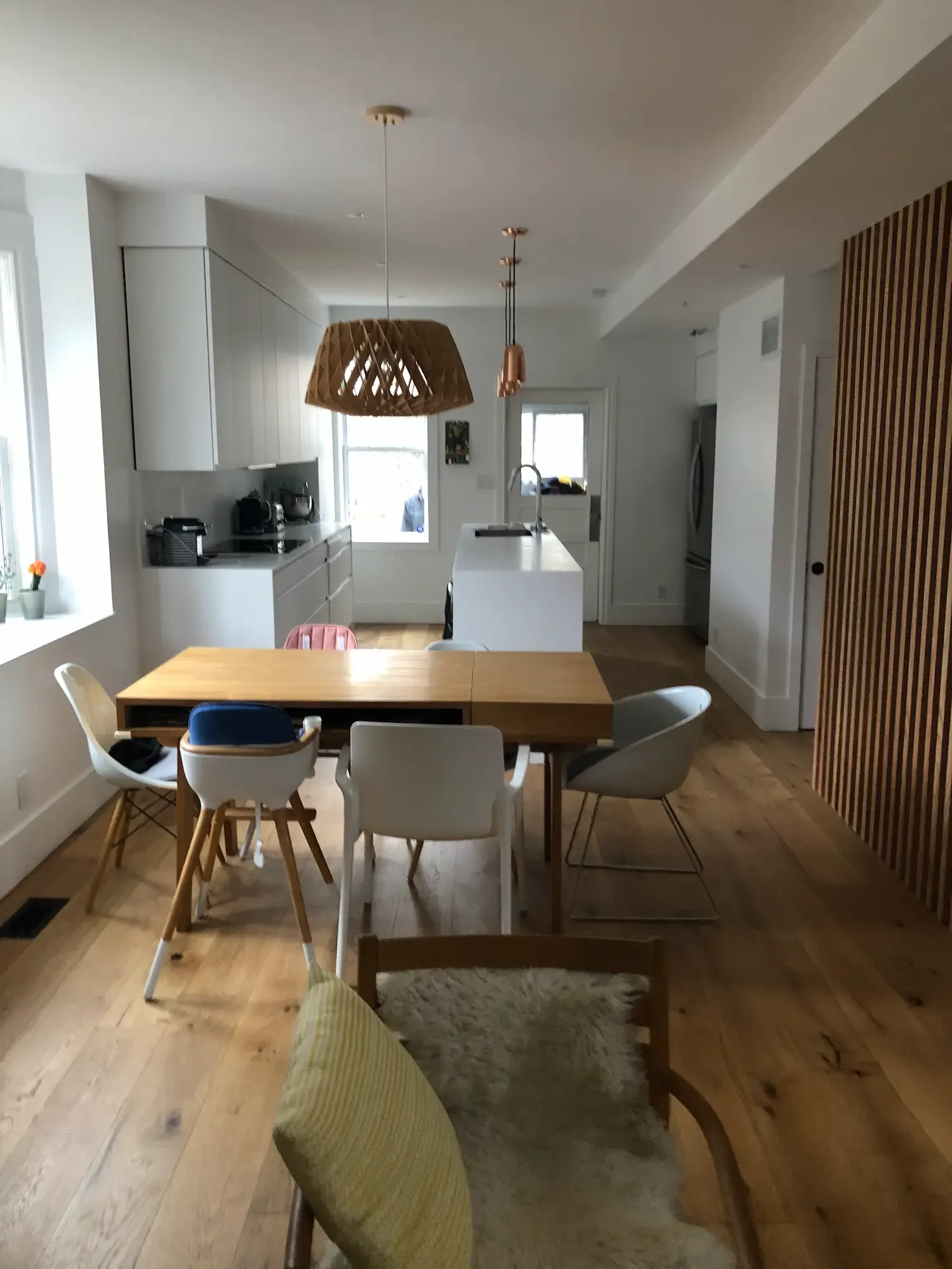 Kitchen and dining area with woven pendant light and white island - The Beaches Toronto by Odin Agnuk