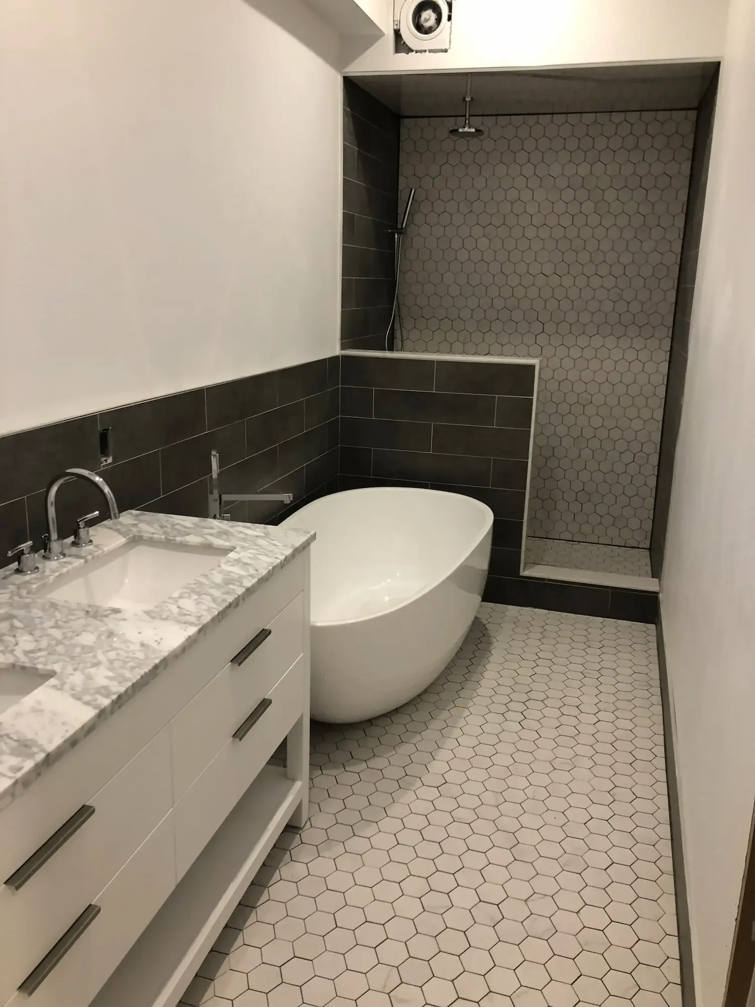 Bathroom renovation with freestanding tub, walk-in shower, and hexagon tile floor - Grey County by Odin Agnuk