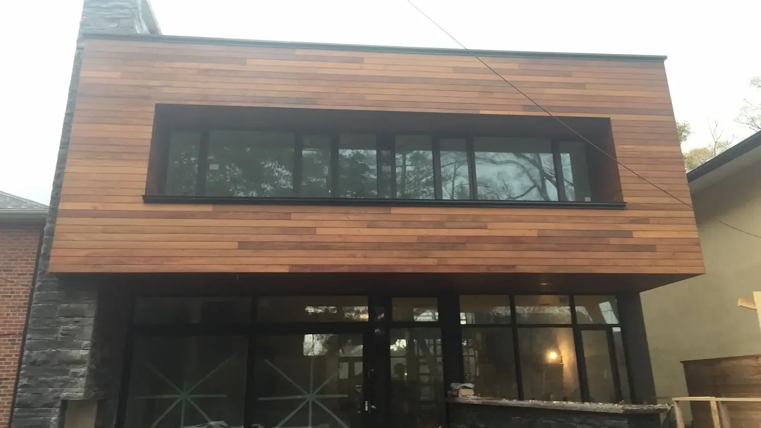 Ipe siding box frame detail with curtain wall glazing on custom home in Toronto by Odin Agnuk