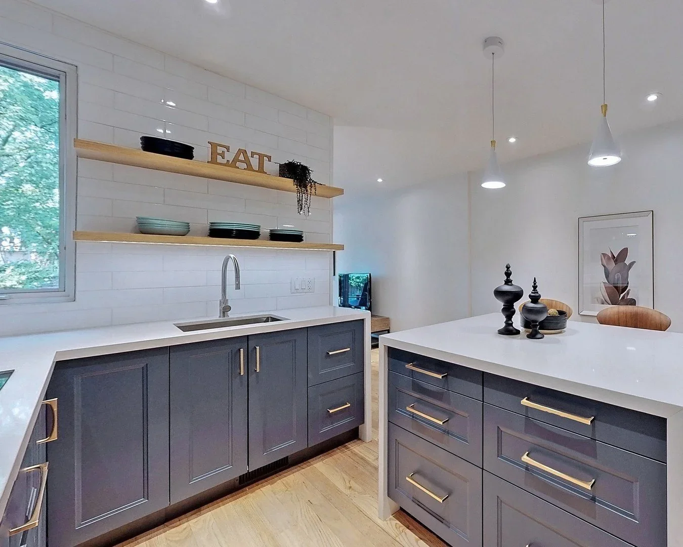 Custom kitchen with quartz waterfall island and floating shelves in Leslieville by Odin Agnuk

