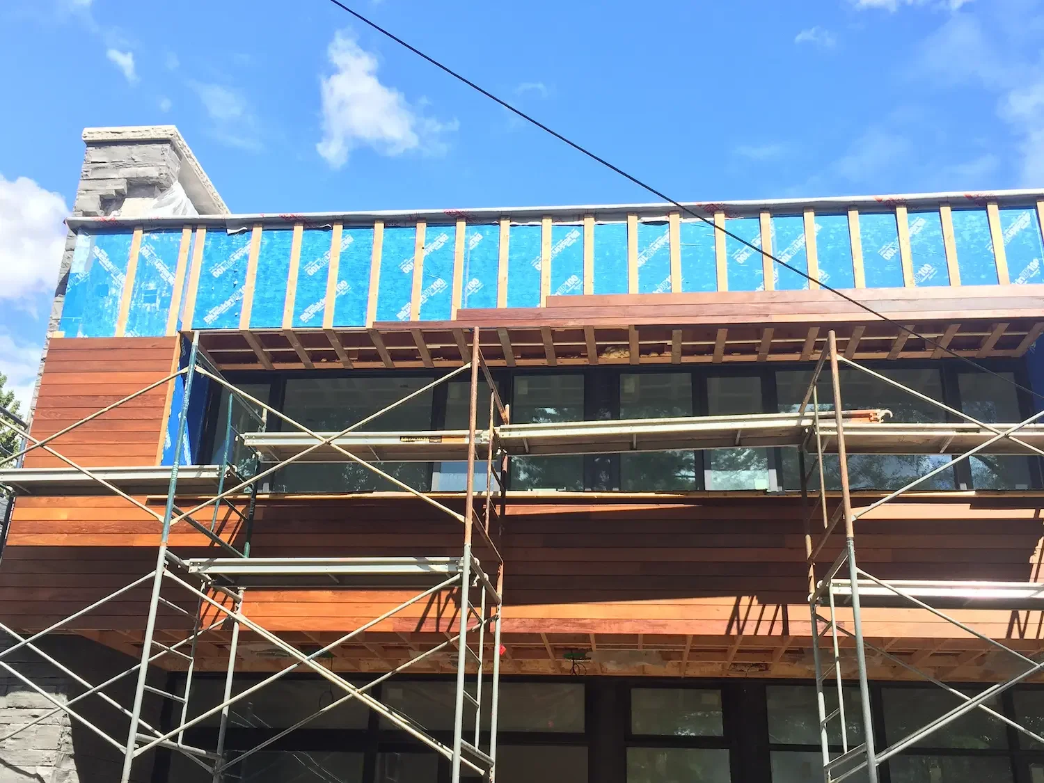 Horizontal ipe siding installation in progress on custom home in Toronto by Odin Agnuk