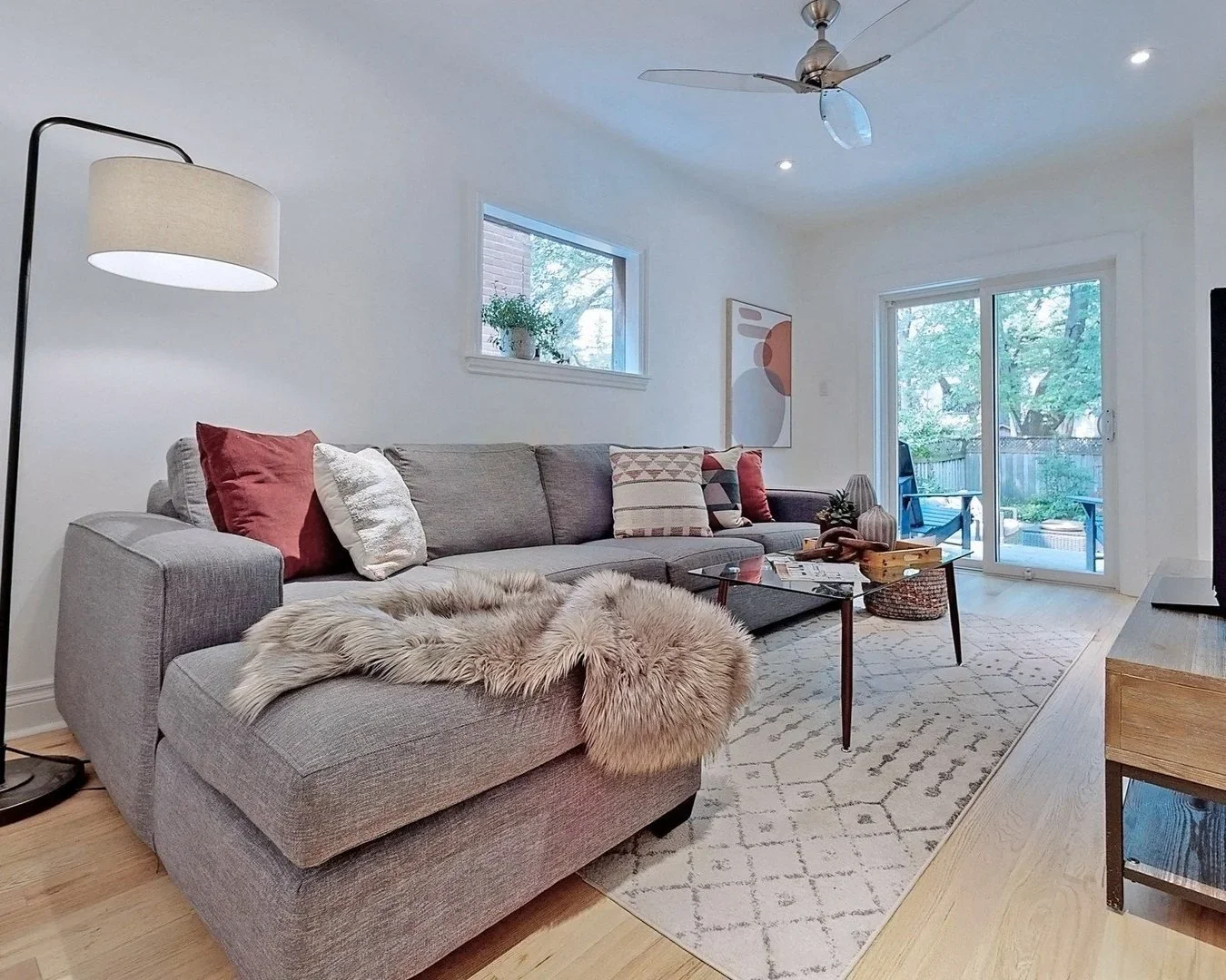 Living room renovation with refinished hardwood floors and sliding door to deck in Leslieville by Odin Agnuk