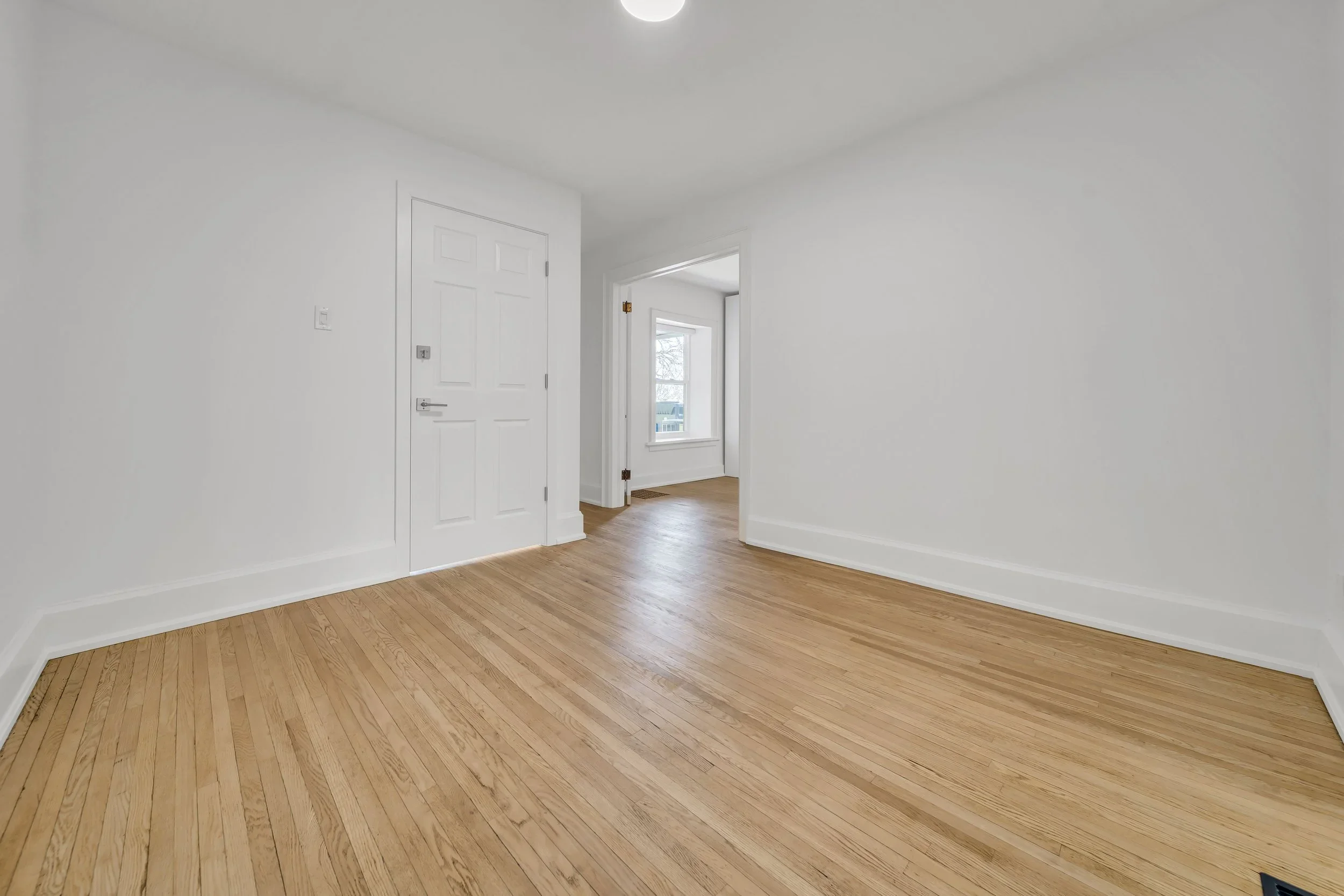 Foyer with refinished hardwood floors in Guelph century home duplex conversion by ODIN+AGNUK