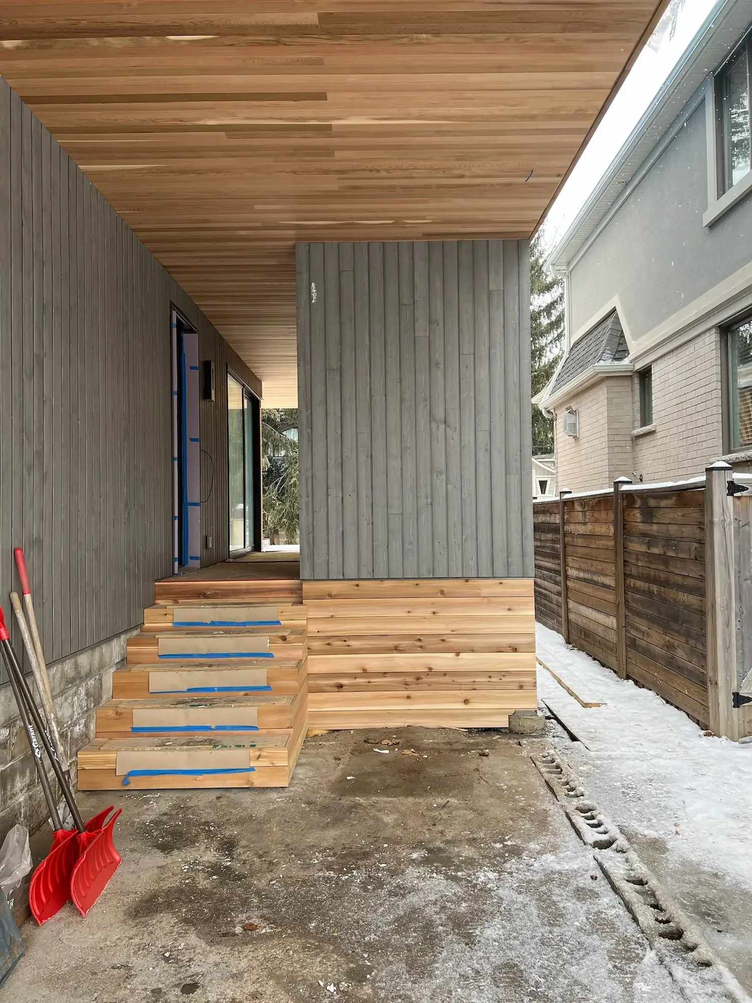 Side view of modern custom home with Maibec vertical siding, cedar ceiling and steps in Etobicoke by Odin Agnuk