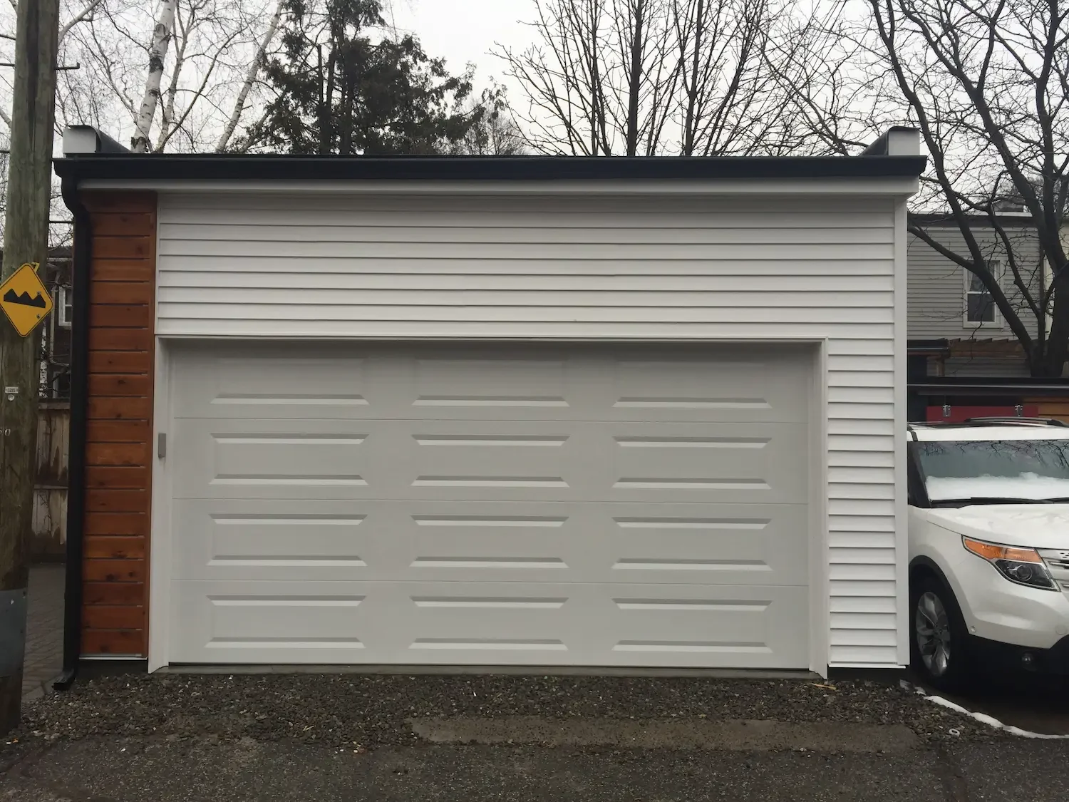Completed garage with vinyl siding garage door and cedar accent in Toronto by Odin Agnuk