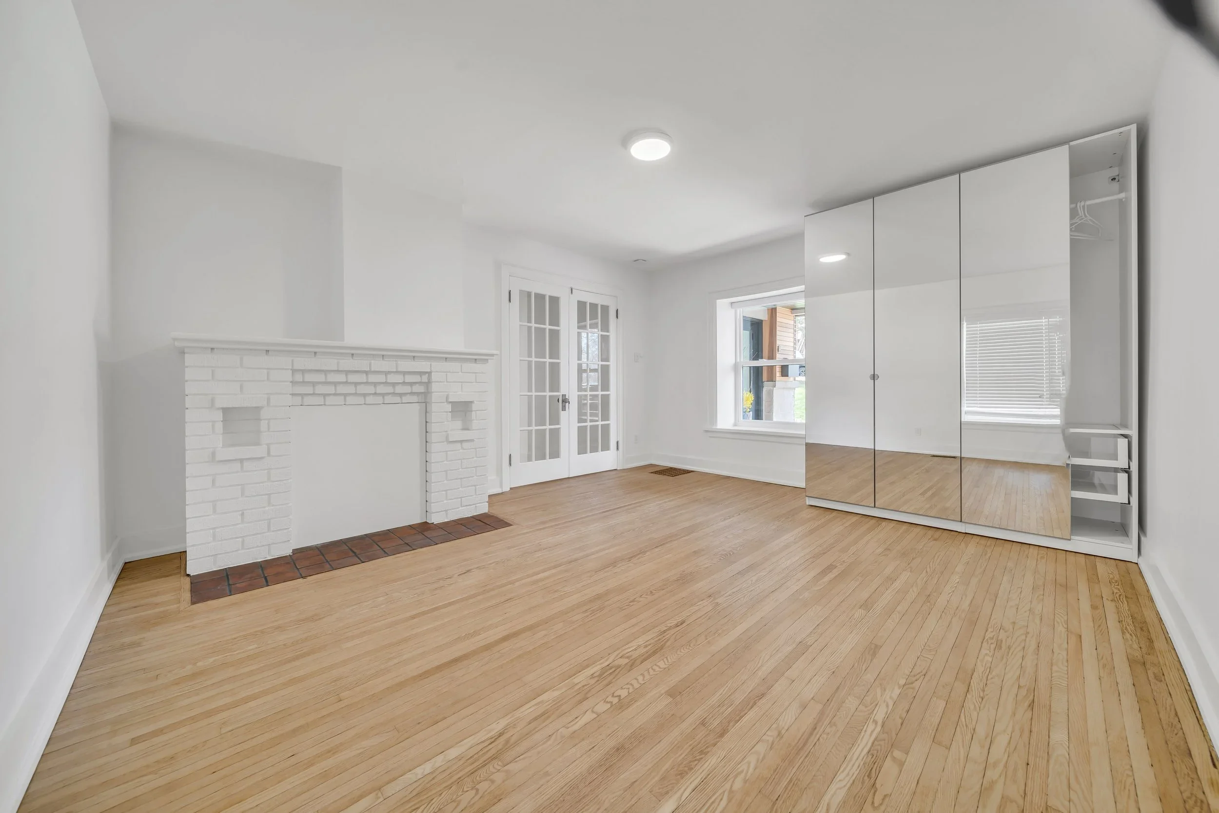 Bedroom with refinished hardwood floors in Guelph century home duplex conversion by ODIN+AGNUK