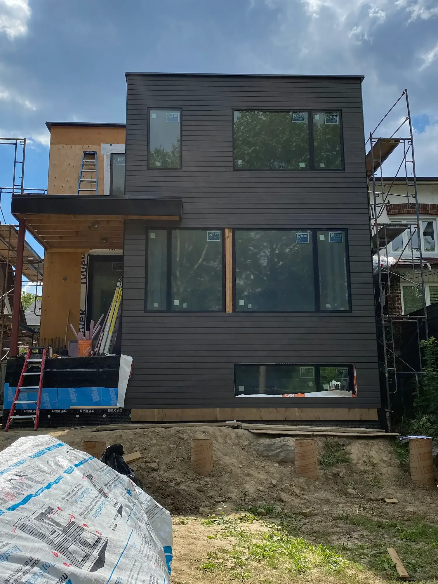 Maibec grey horizontal cladding installation in progress with scaffolding - Toronto by Odin Agnuk