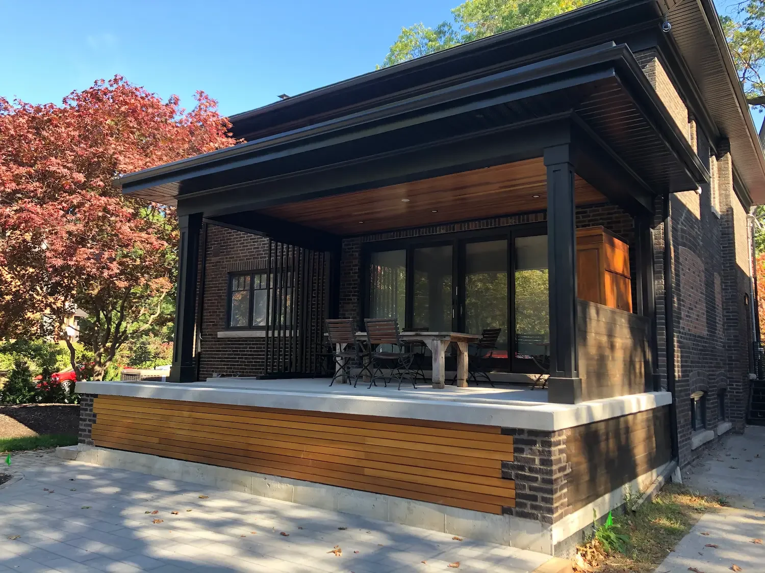 Completed covered patio with cedar ceiling and privacy screen at Roncesvalles home by Odin Agnuk