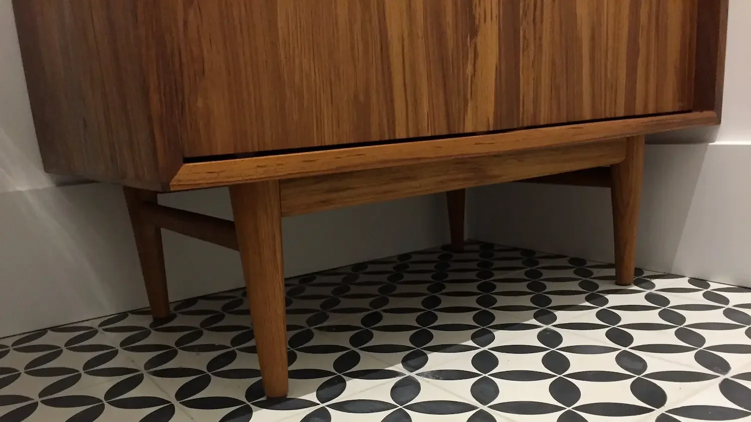 Custom teak vanity with tapered legs on black and white patterned tile - The Beaches by Odin Agnuk