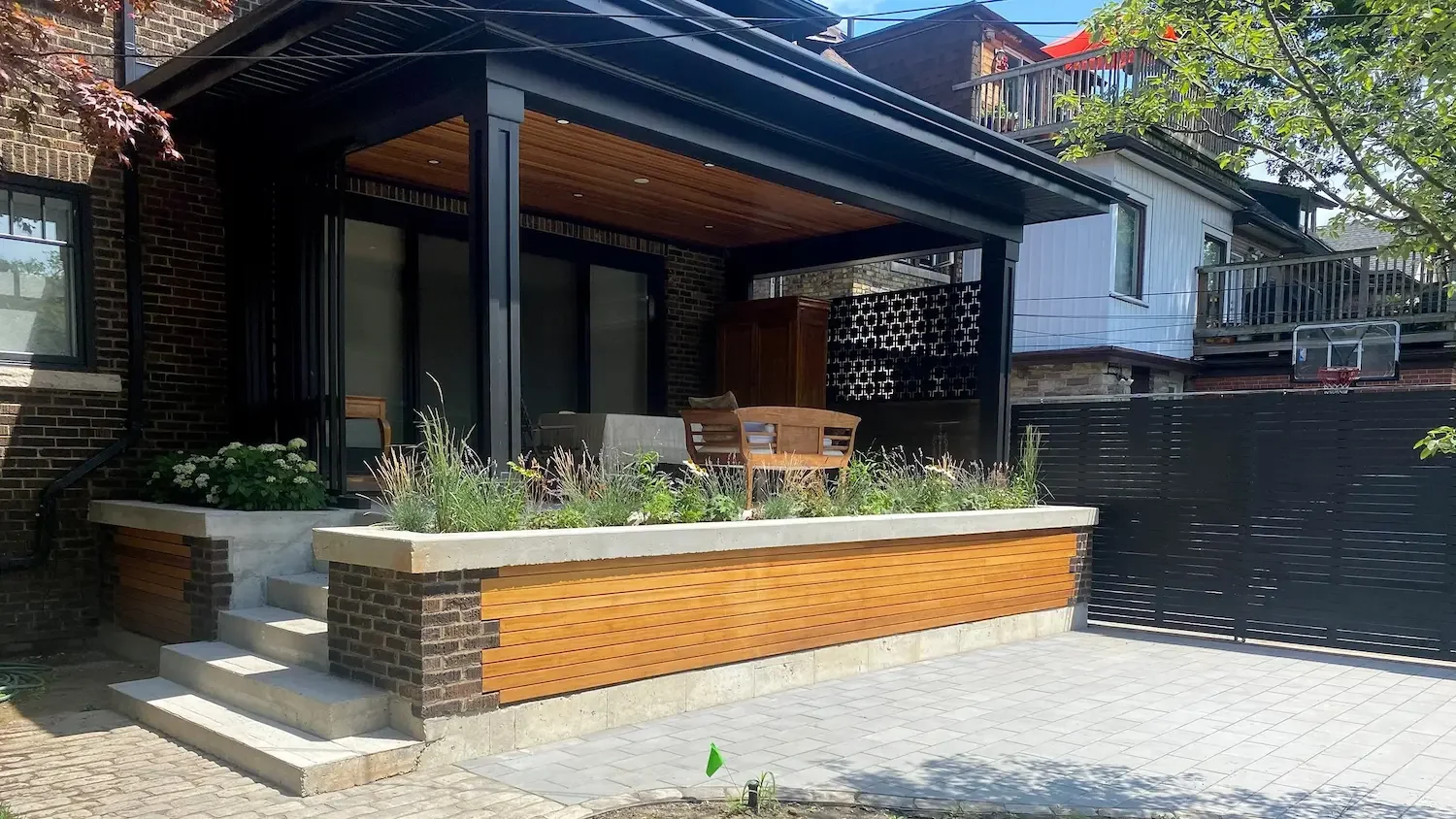 Completed covered patio with built-in planter and sliding privacy screen in Roncesvalles by Odin Agnuk