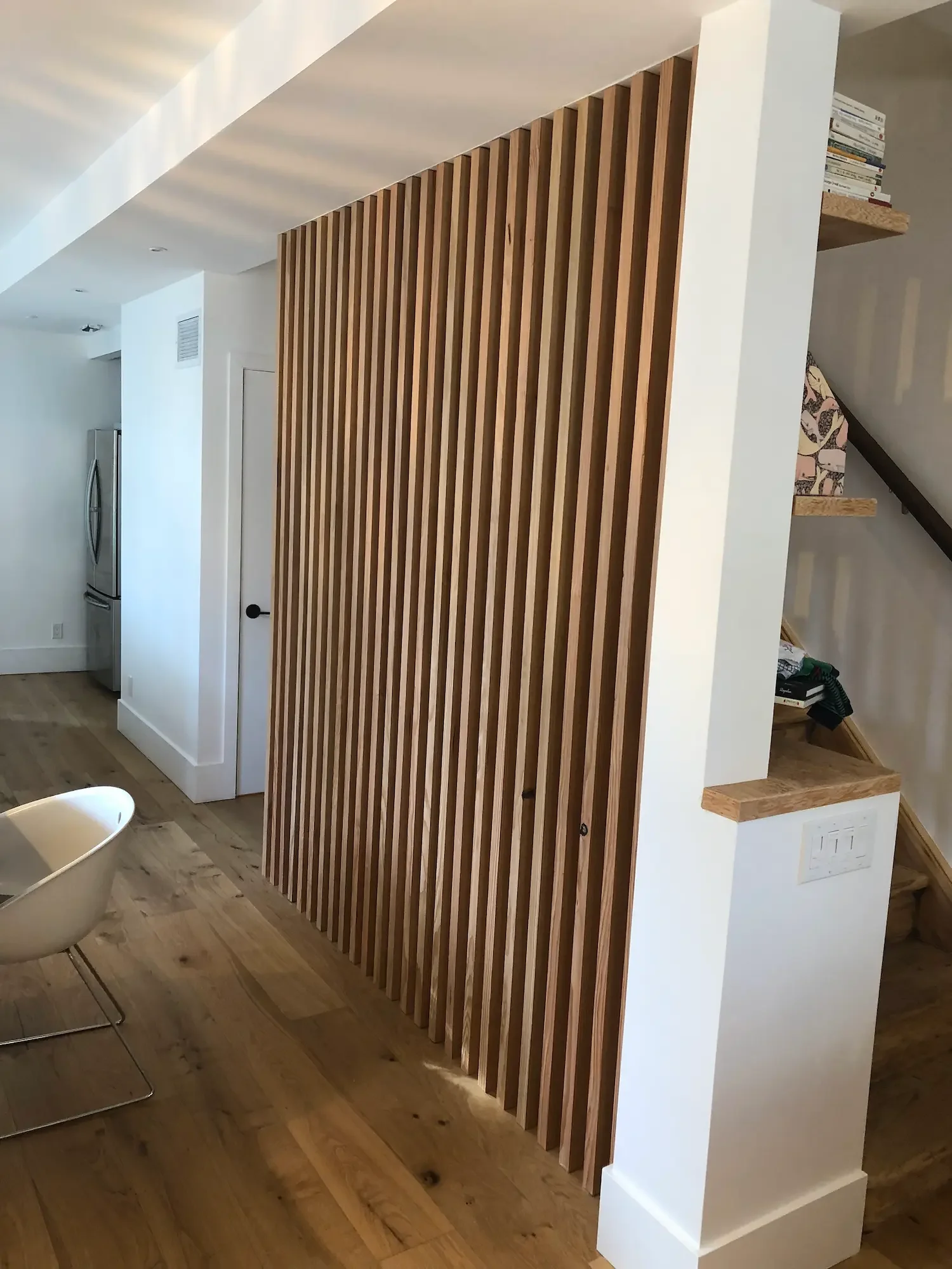 Floor-to-ceiling architectural screen with floating shelves at staircase - The Beaches by Odin Agnuk