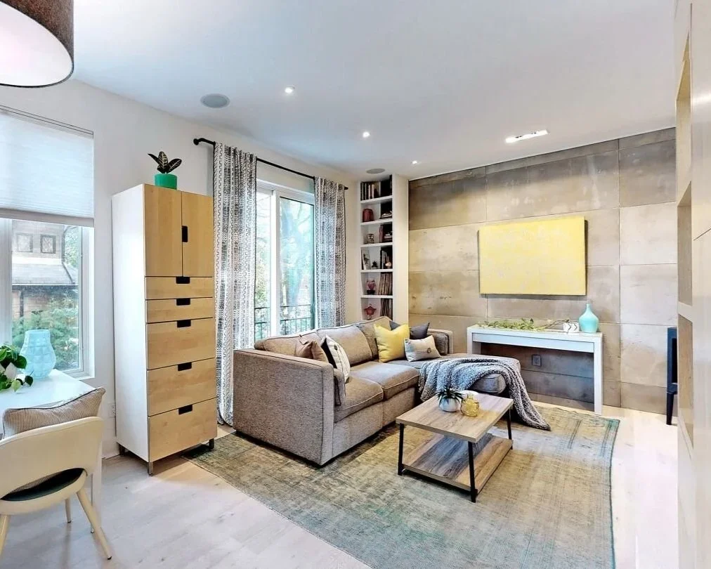 Open concept living room with concrete feature wall and modern wood stove at home in The Pocket Toronto by Odin Agnuk