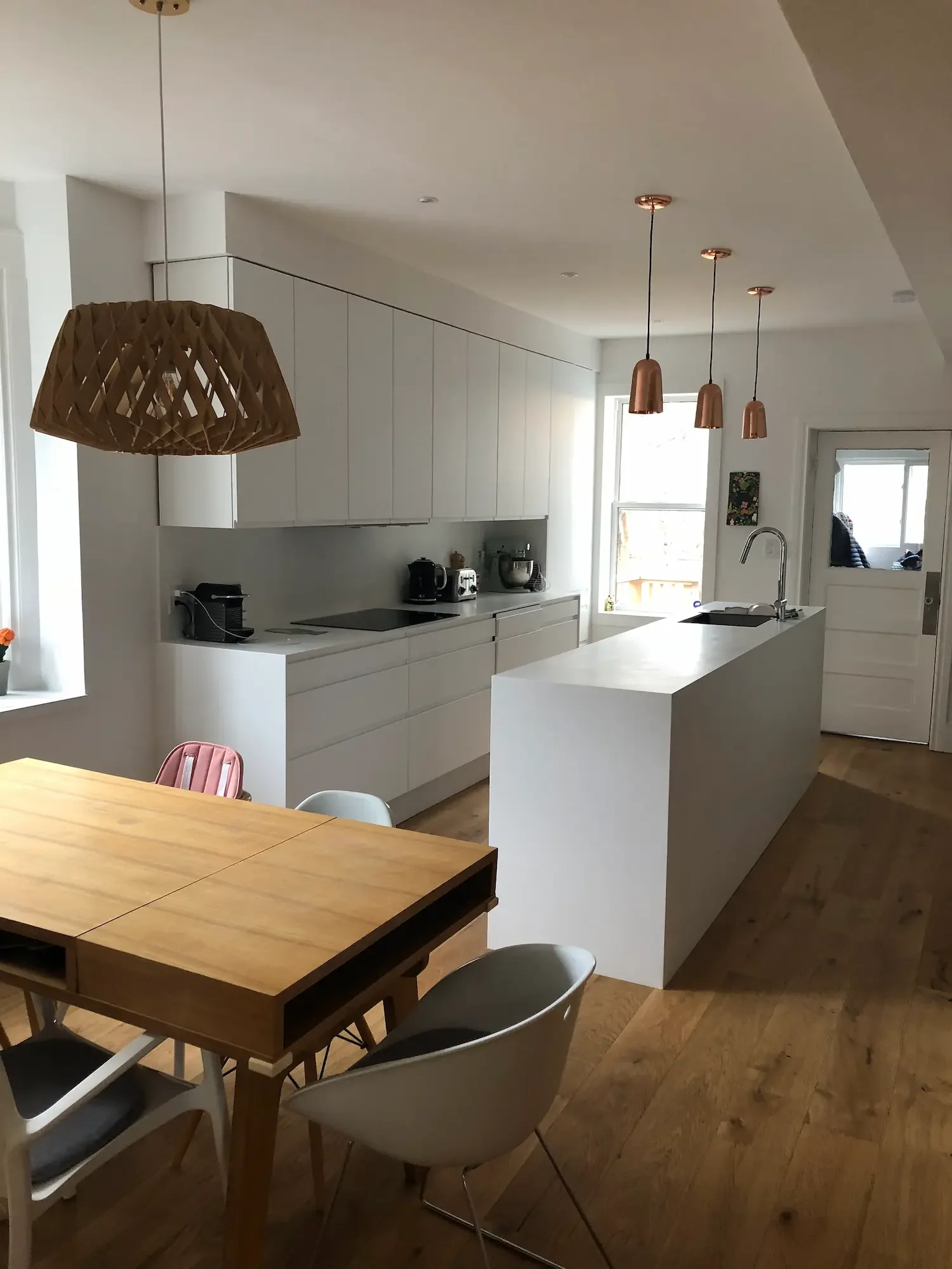 Modern white kitchen with copper pendant lights and waterfall island - The Beaches Toronto by Odin Agnuk