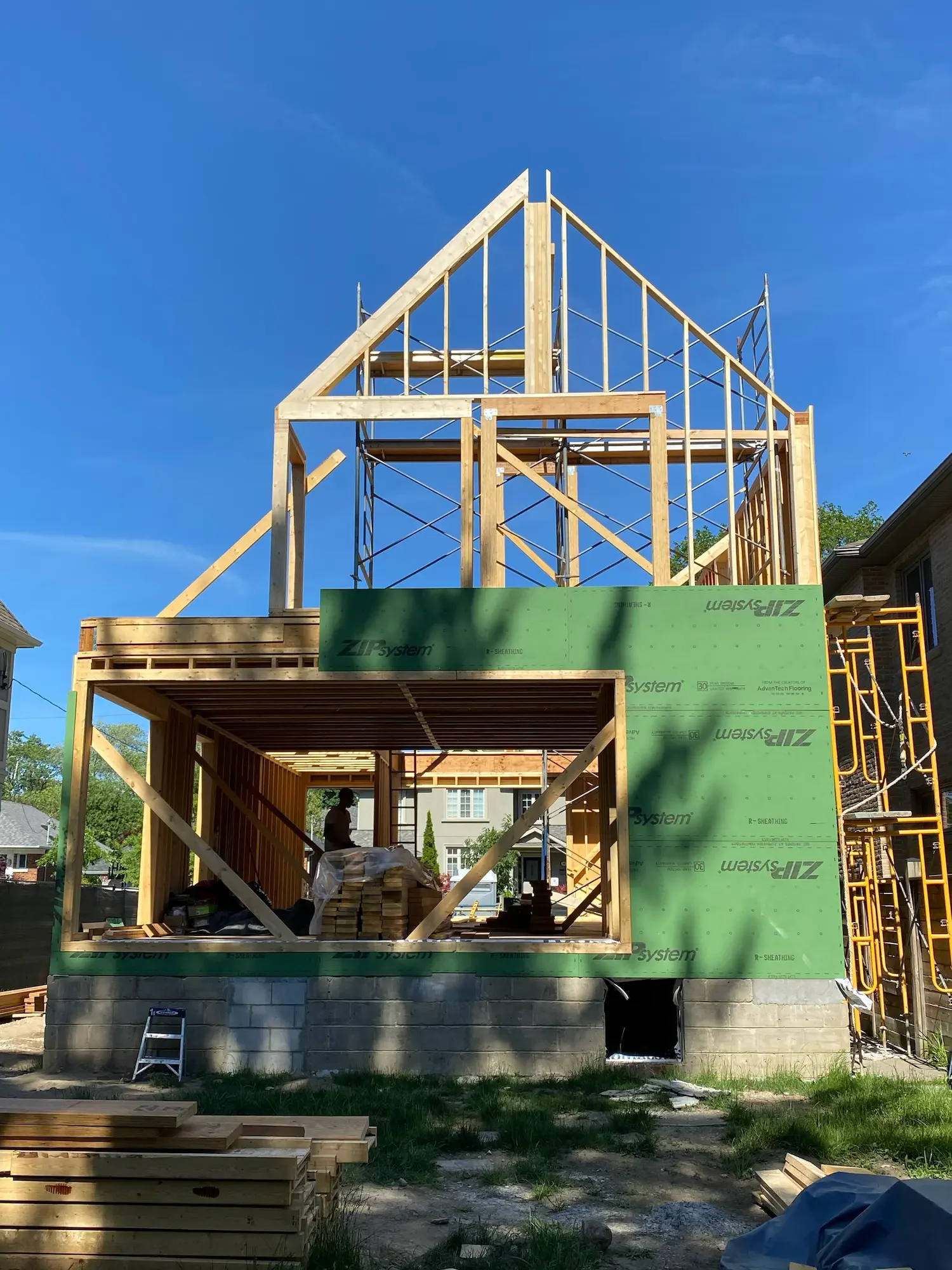 Gable roof framing with ZIP System sheathing and covered deck structure at custom home in Etobicoke by Odin Agnuk