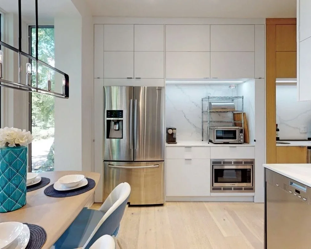 Kitchen with floor-to-ceiling cabinets and stainless steel appliances in The Pocket, Toronto by Odin Agnuk