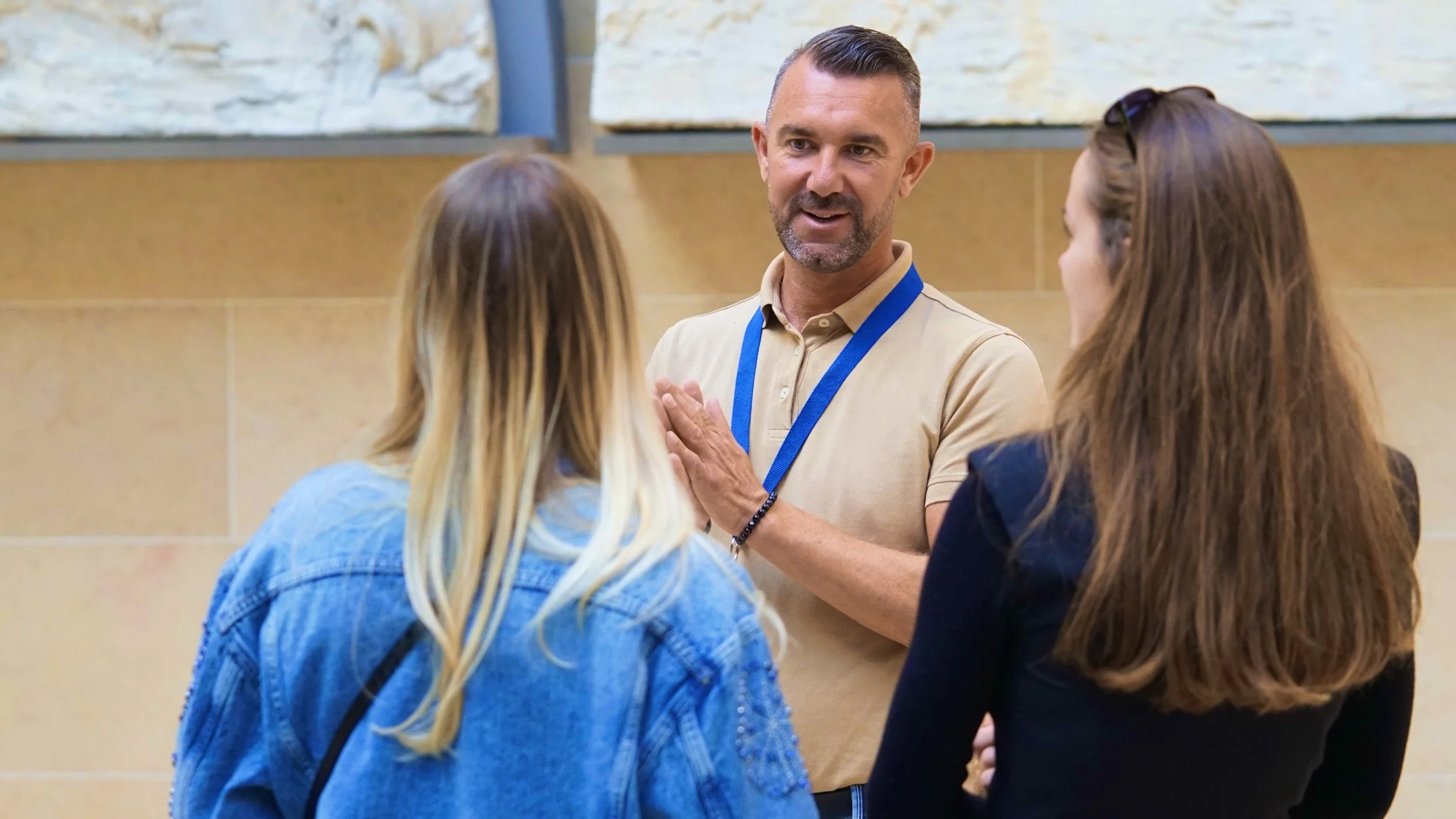 Pascal Billaud as a Tour Guide in Louvre explaining art to two women visitorsg