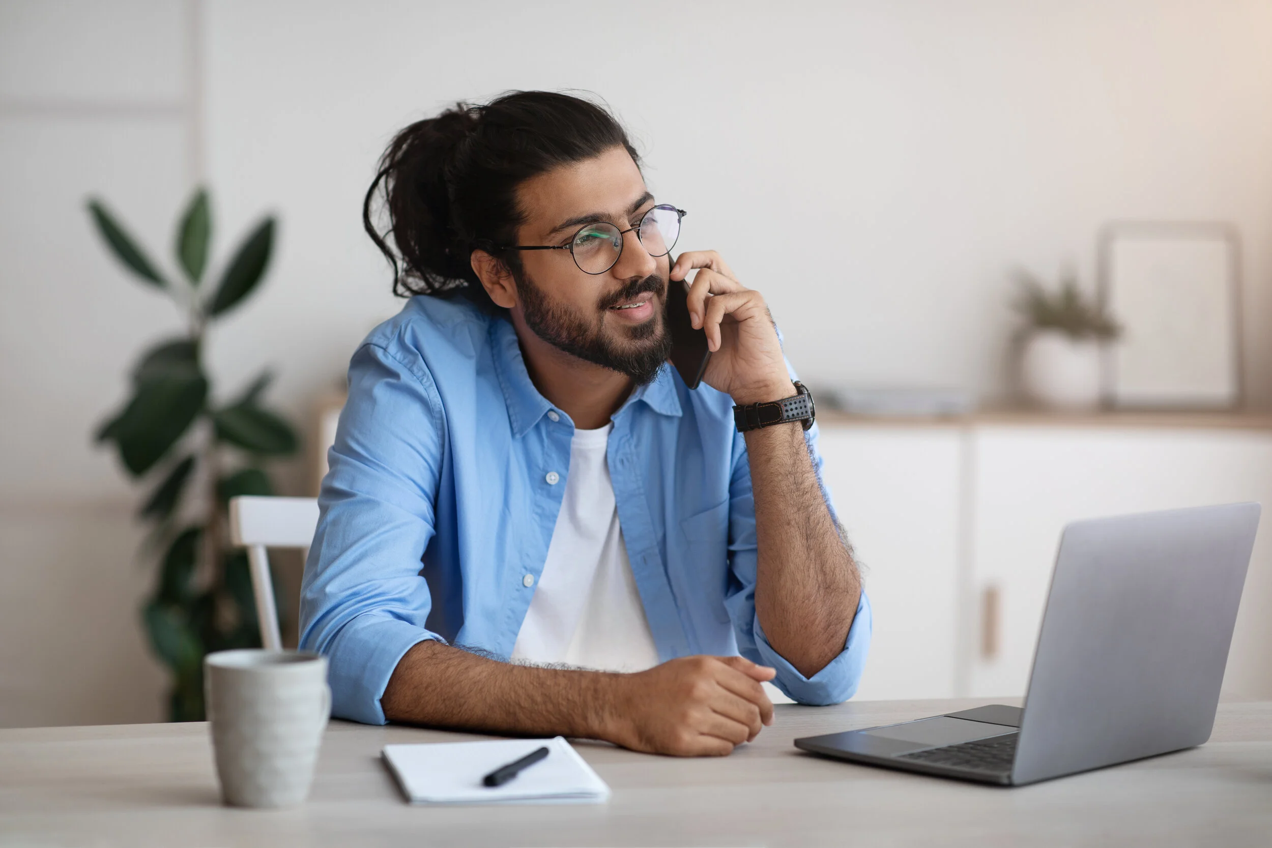 millennial-indian-man-talking-on-cellphone-and-usi-SMBN3MA.jpg