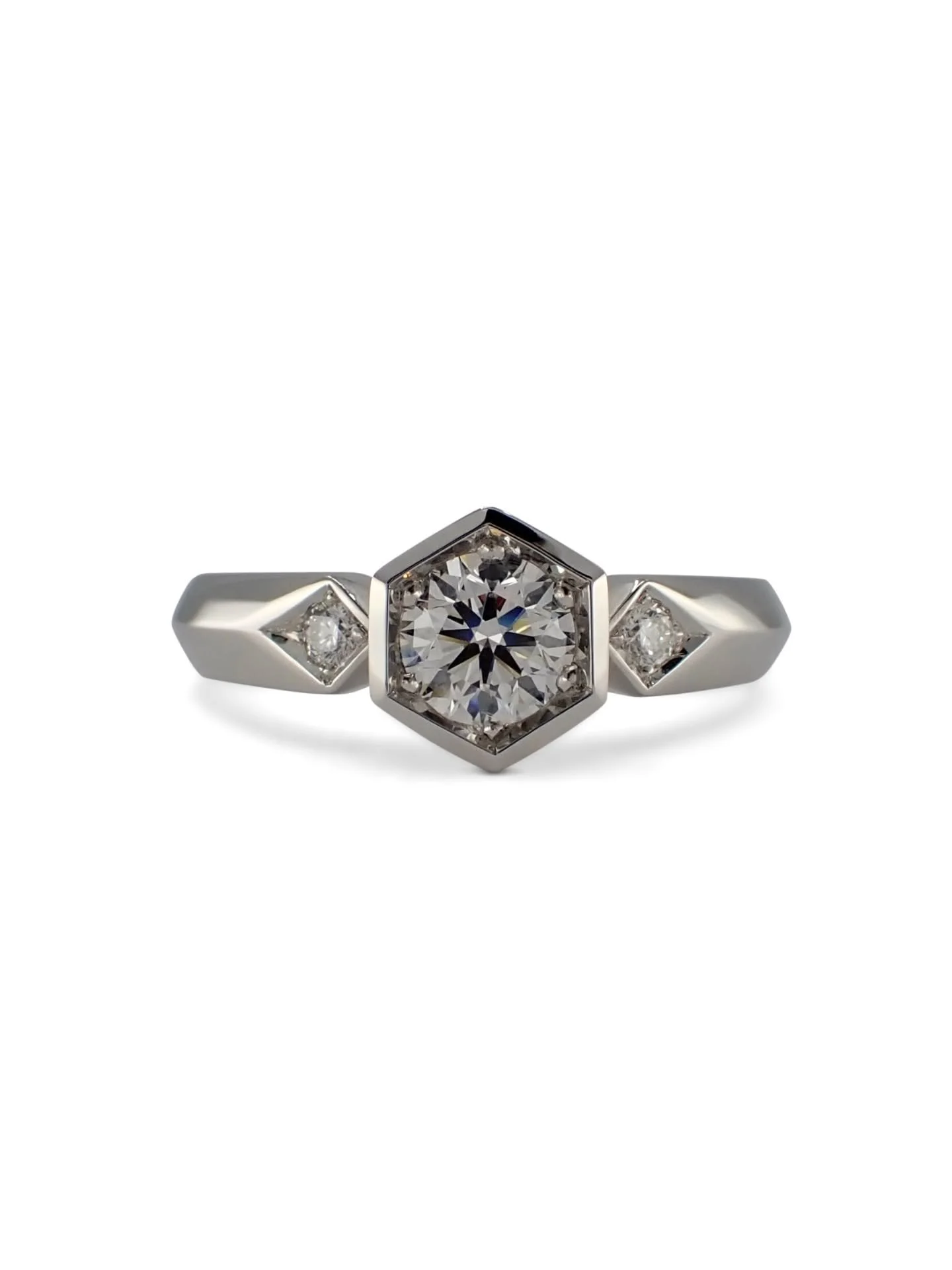 Lots of clients come to me because they feel like the general engagement ring market is a bit like fitting a square peg in a round hole.... too much of the same look, and not quite right for them. 

Enter the round diamond in a hexagon setting design
