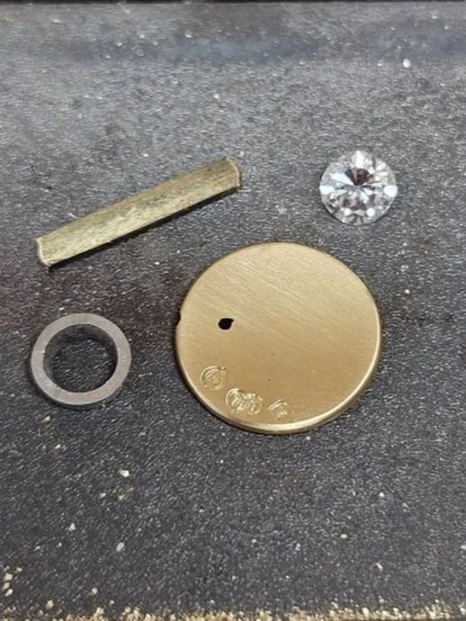 Raw gold and gemstones on a jeweller's workbench