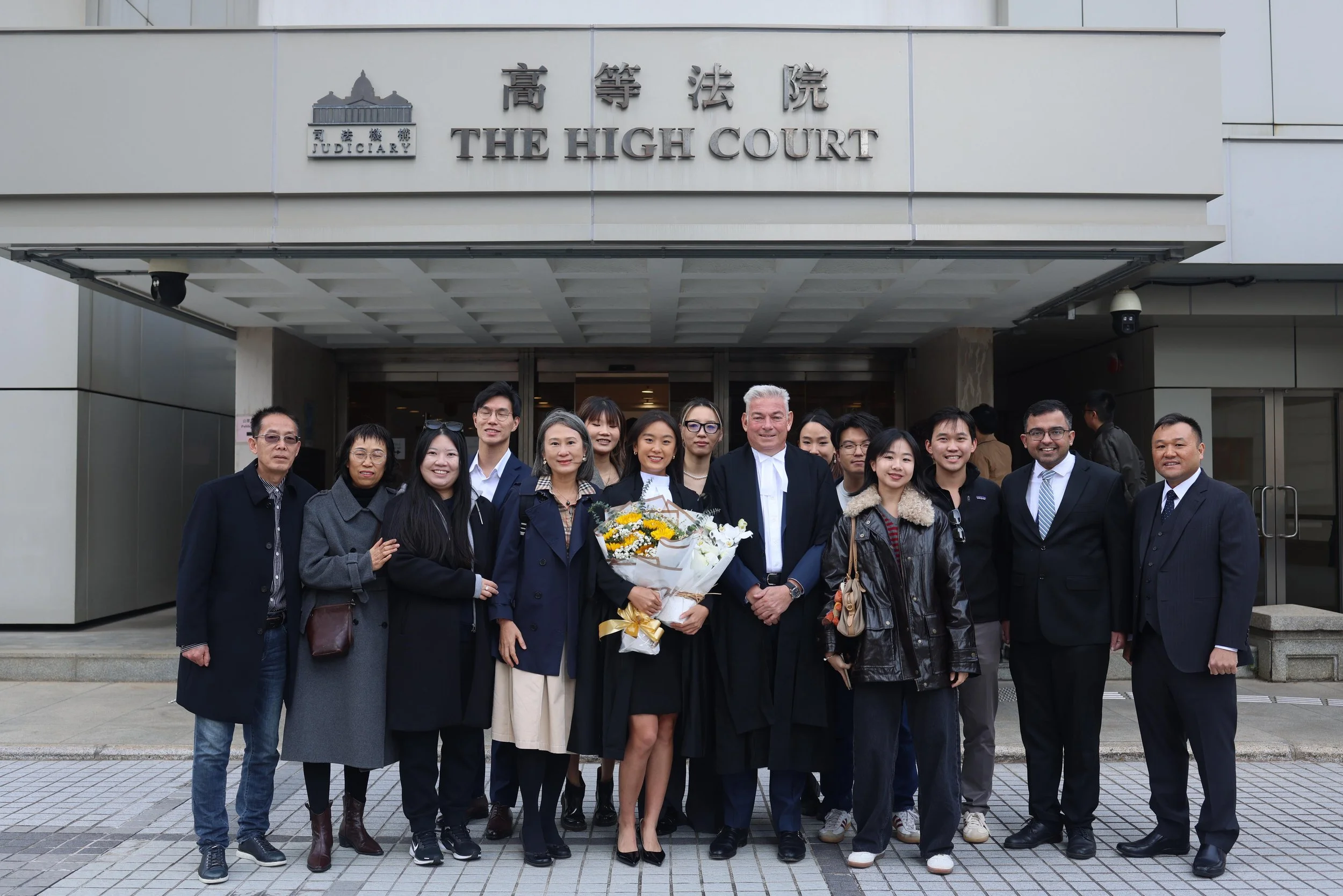 Bowers Law team smiling outside The High Court, with congratulatory flowers
