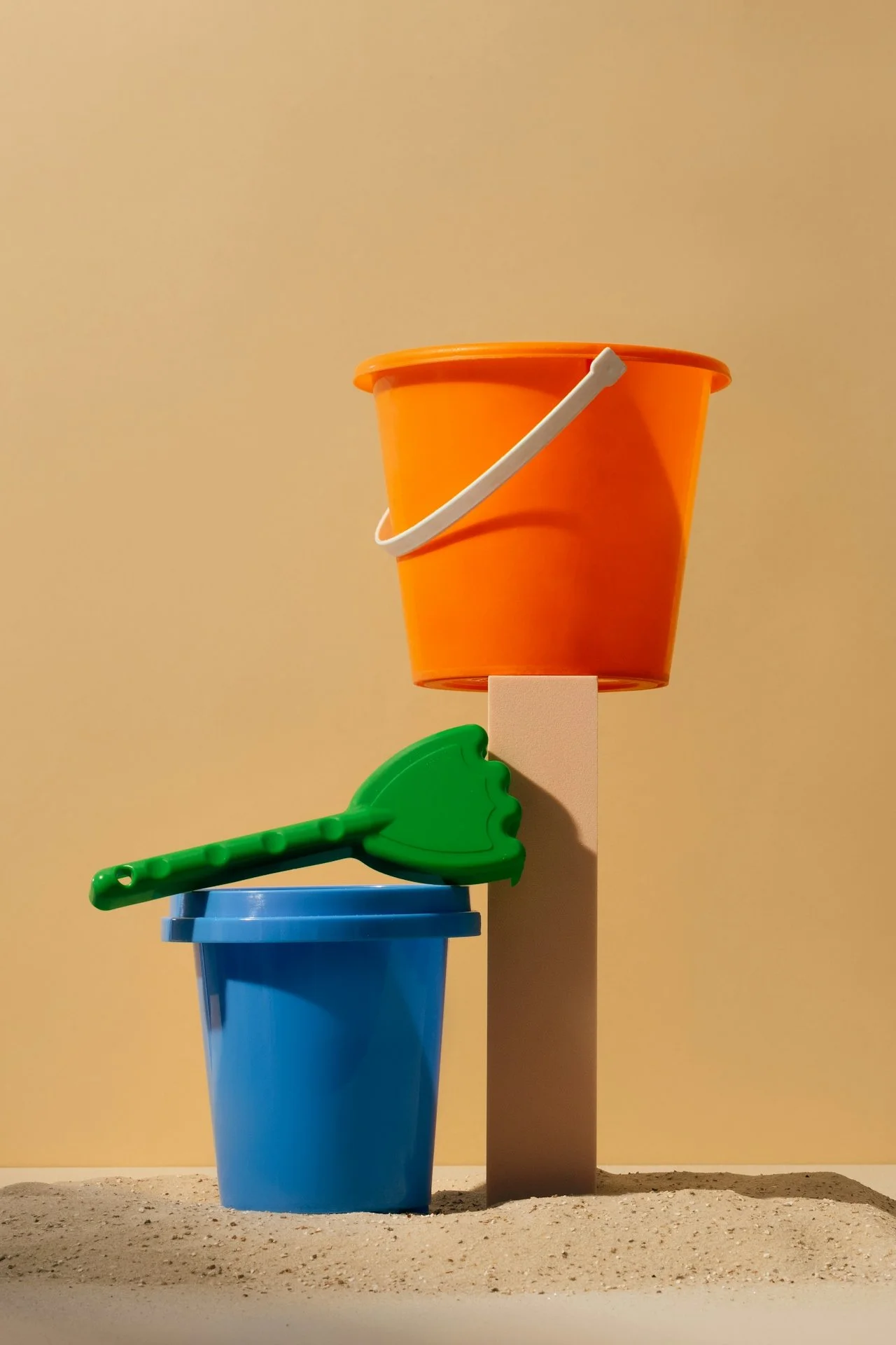 Minimal buckets and spade with sand, bright, orange, blue, and colourful