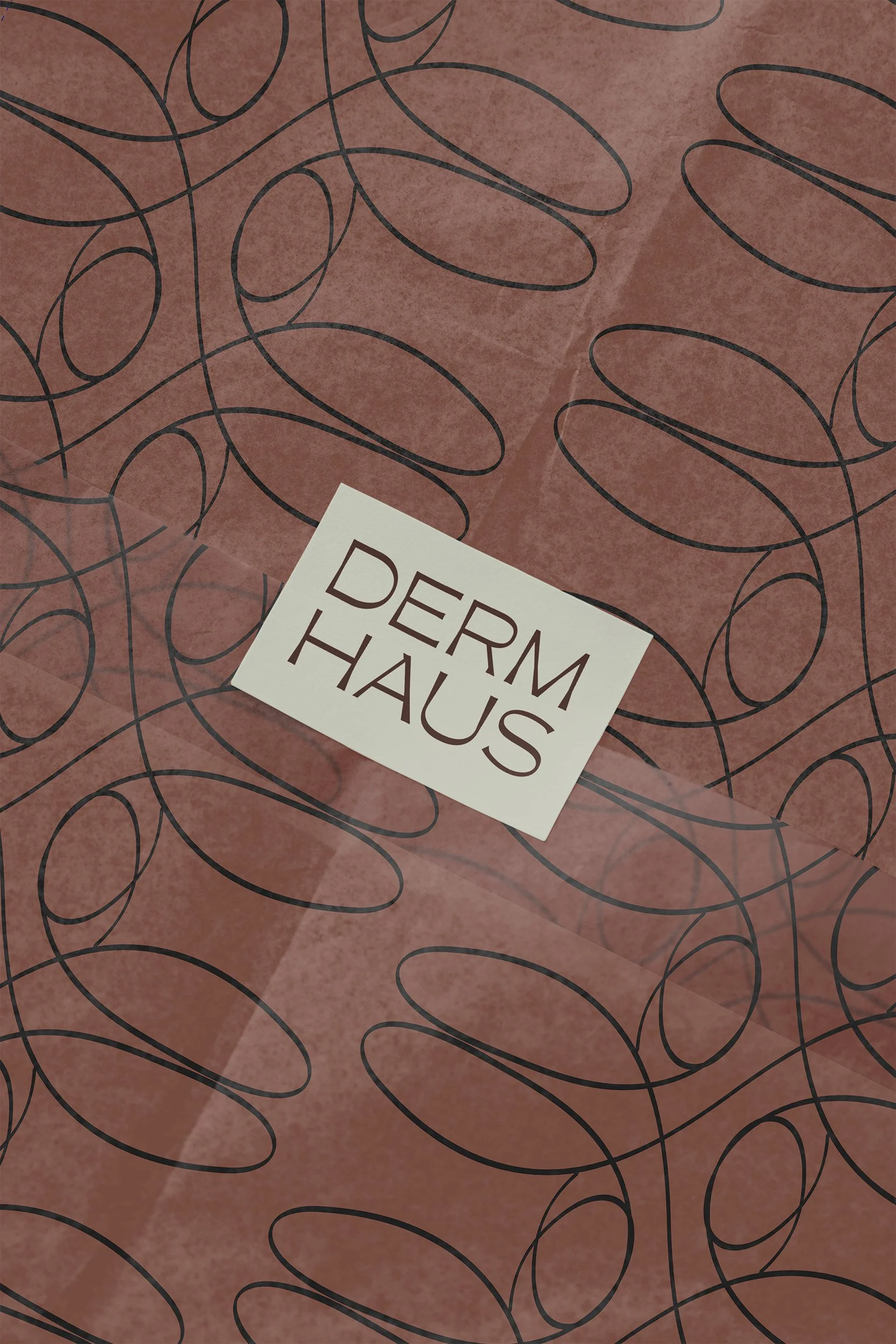 Derm Haus branded tissue paper packaging with custom loop pattern made from a letter 'D', brand collateral design for Brisbane skin clinic