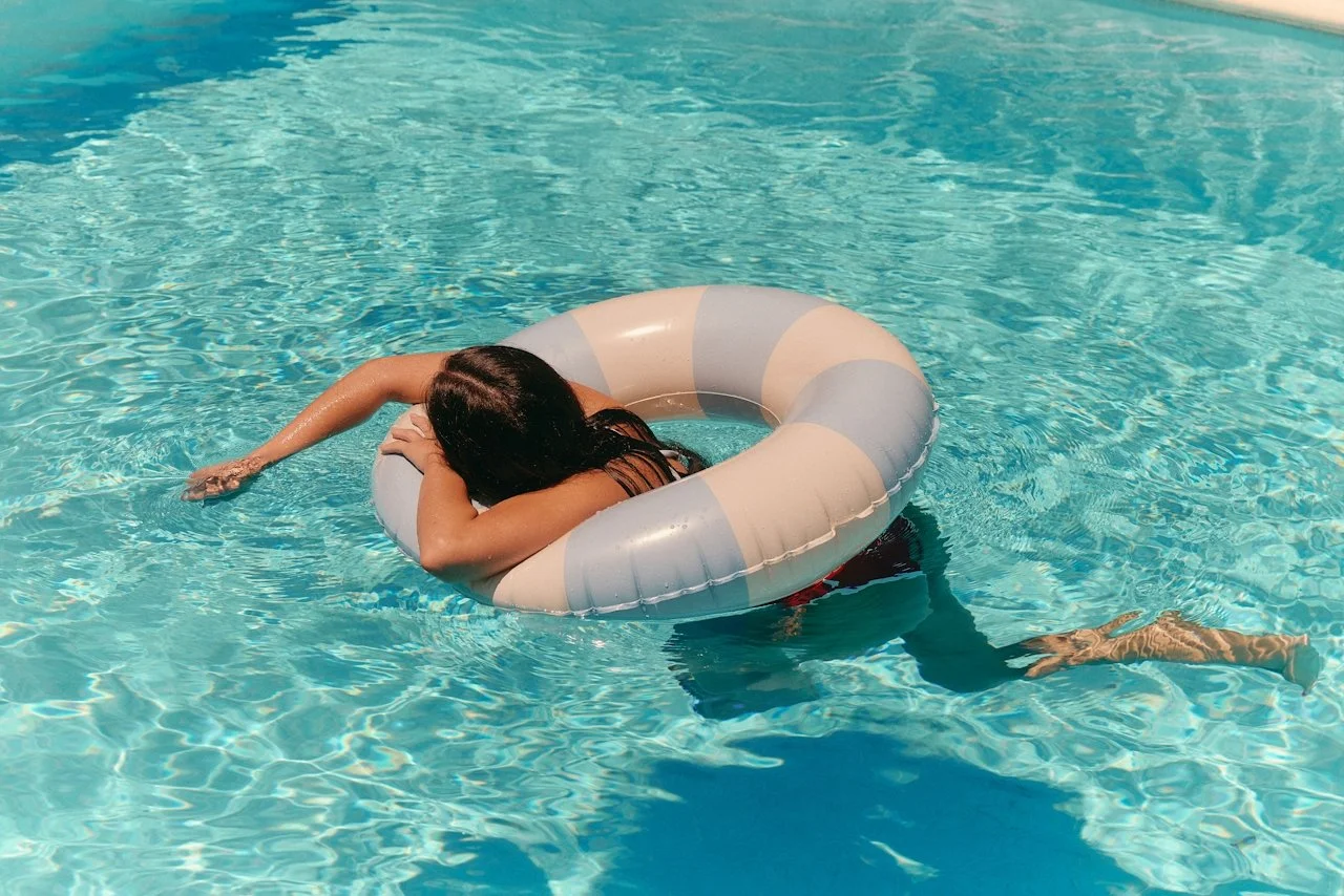 Person floating on inflatable ring in pool