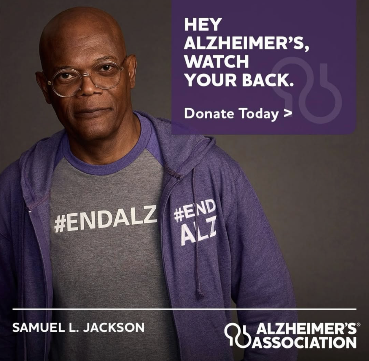 Samuel L. Jackson wearing glasses and a purple hoodie with '#ENDALZ' printed on a gray t-shirt. There is a purple text box with white text that reads: 'Hey Alzheimer’s, watch your back.