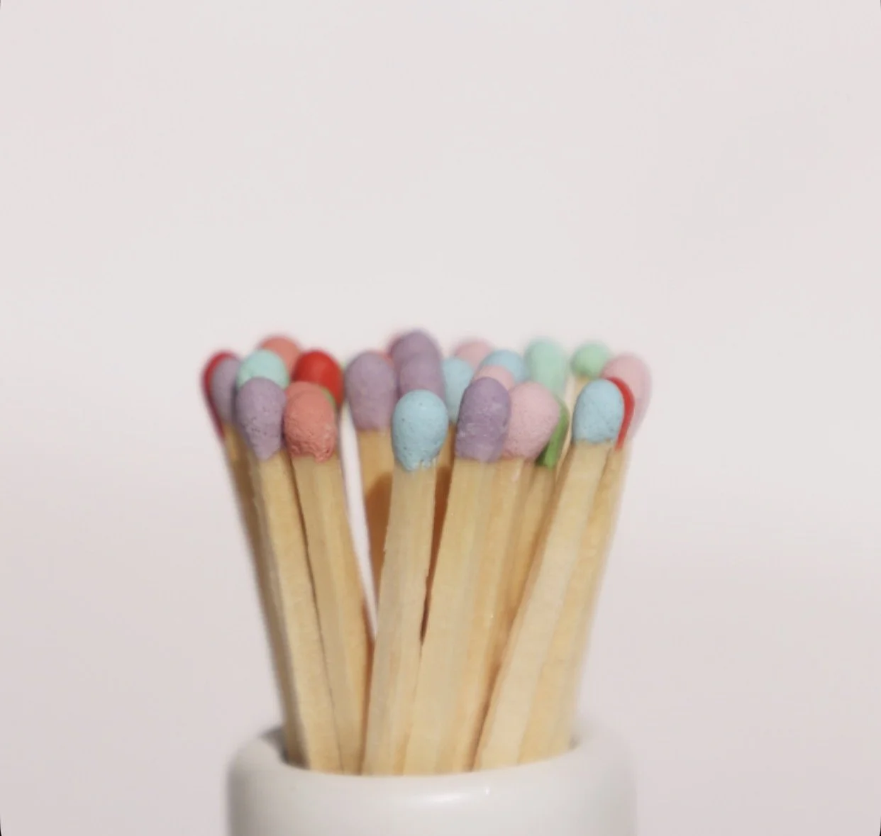 Pastel-colored match sticks in soft pink, lavender, and mint green for home decor.