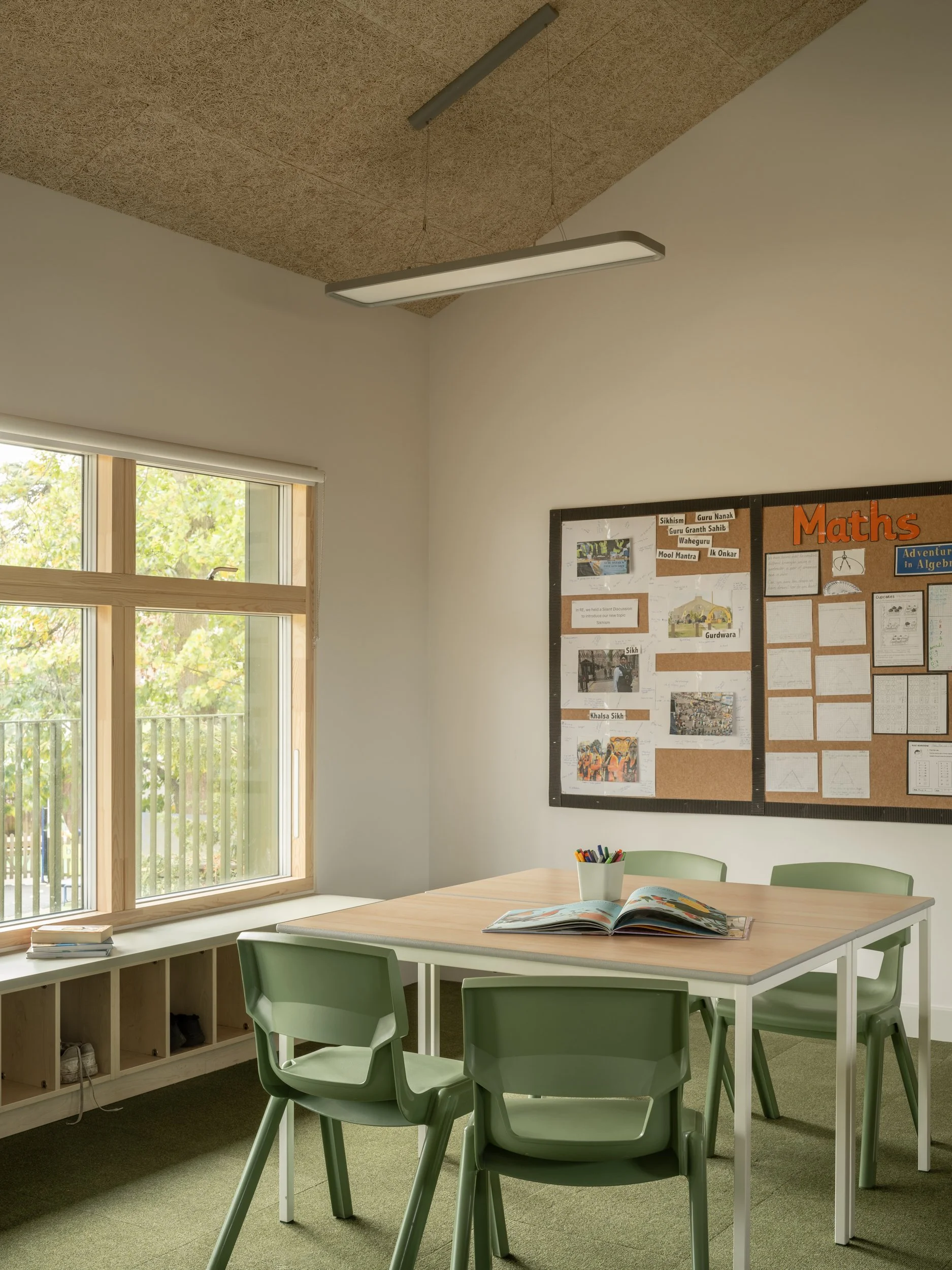 Prep school classroom with timber-framed windows, acoustic ceiling panels, and flexible learning furniture designed to support calm, pupil-centred learning environments.