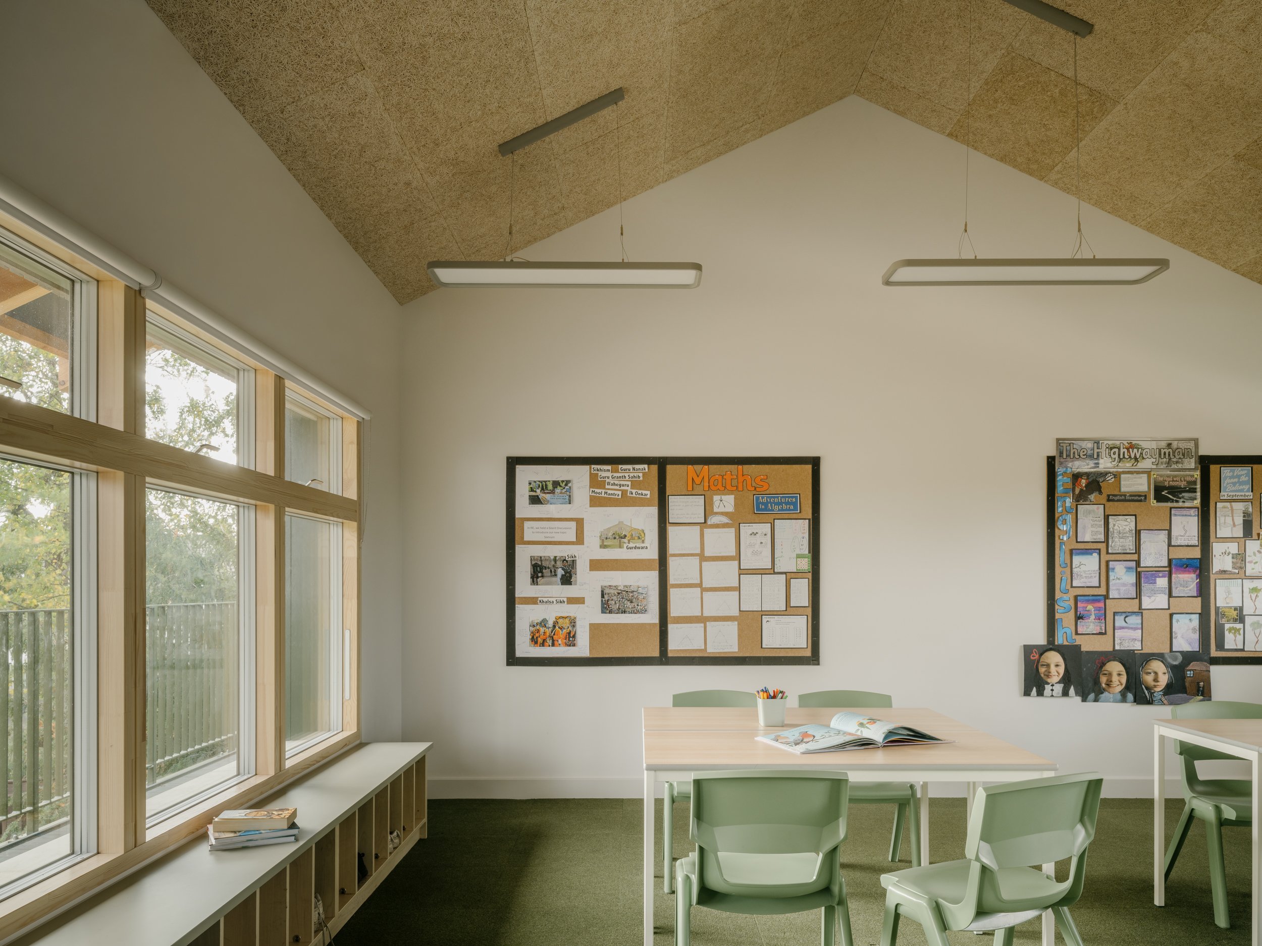 Prep classroom with large timber-framed windows, acoustic pitched ceiling, and flexible learning tables designed to create a calm and naturally lit educational environment.