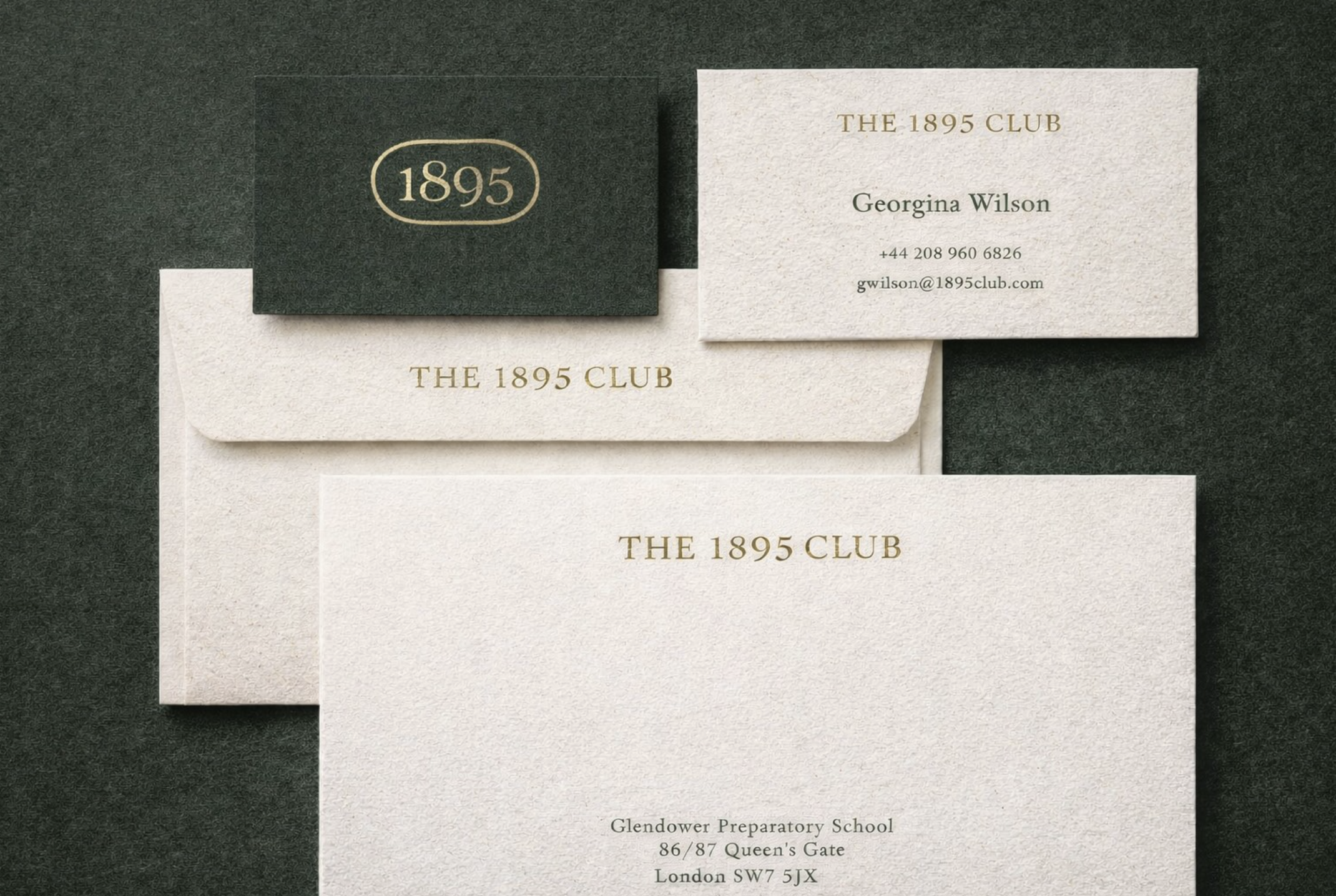 Luxury stationery suite for The 1895 Club featuring embossed business cards, branded envelopes, and premium printed materials with refined typography and textured finishes.
