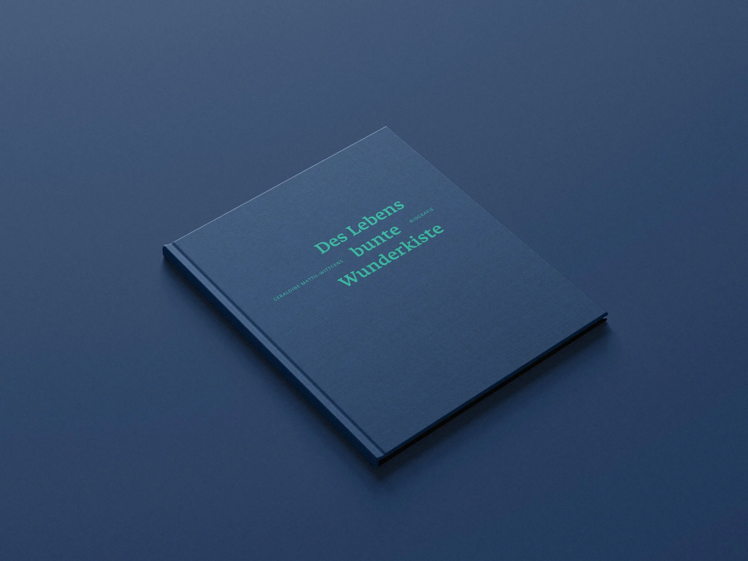 Ein blaues Buch mit dem Titel "Des Lebens bunte Wunderkiste" liegt auf einer blauen Oberfläche.