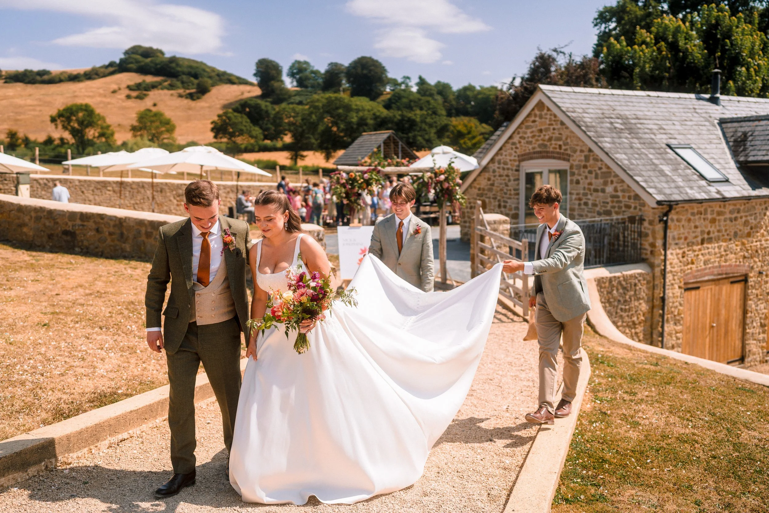 Newlywed couple and groomsmen walking through a rustic stone wedding venue in the countryside