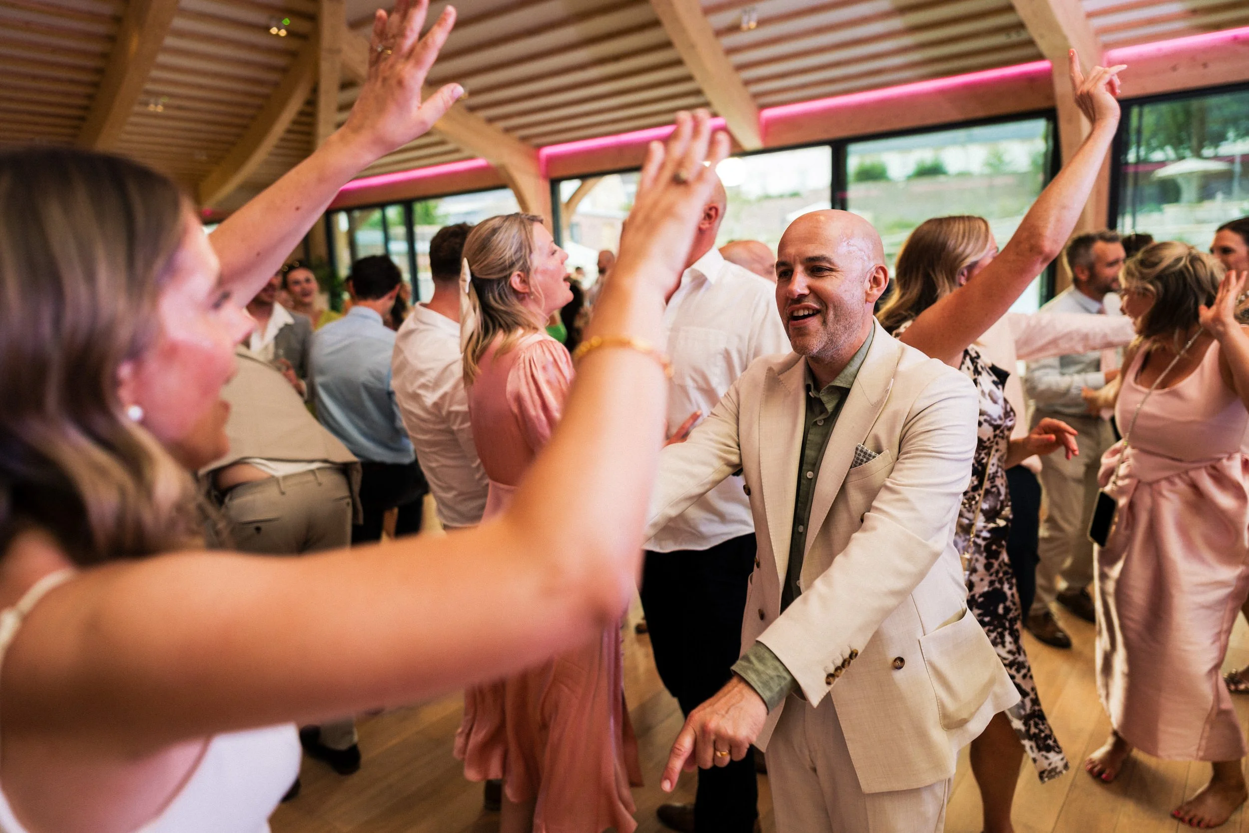 Guests dancing and celebrating at a lively indoor wedding reception.