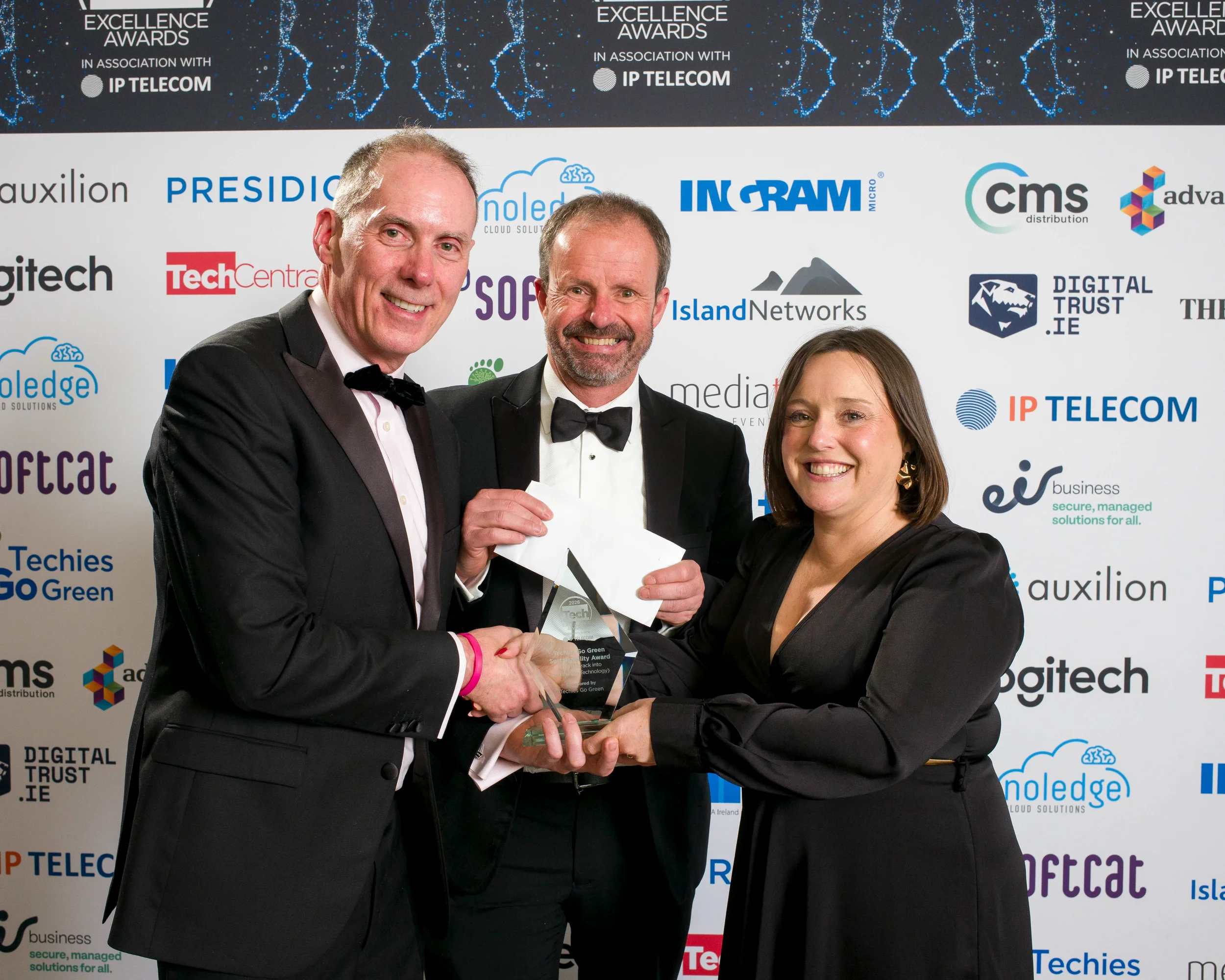 Michael O'Hara, Co-founder of Techies Go Green, presents the Techies Go Green Sustainability Award to Fastrack Into Information Technology (FIT) at the Tech Excellence Awards 2026, joined by Alan Chapman of Comit PR & Marketing.