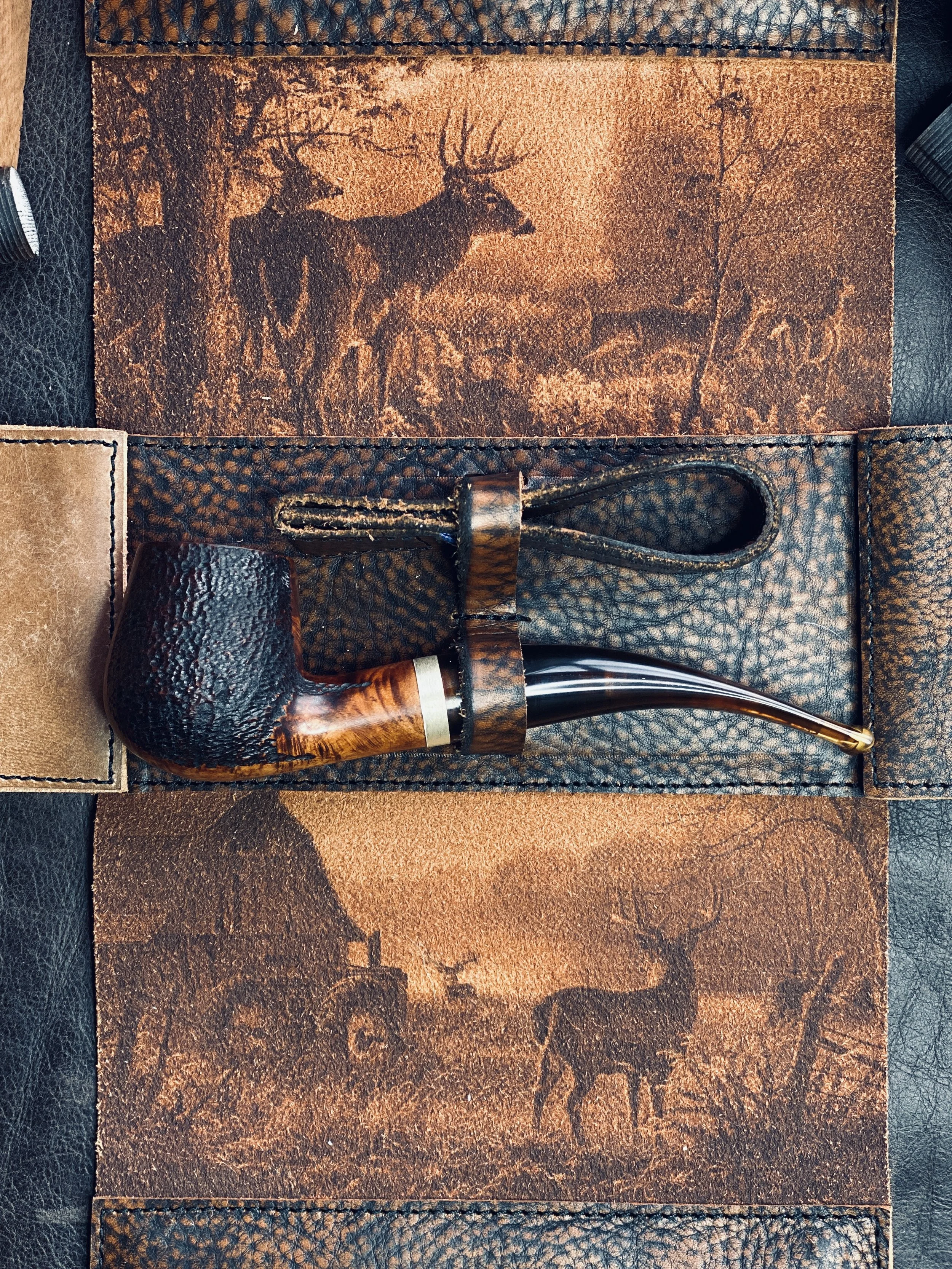 Leather case with deer engraving and tobacco pipe