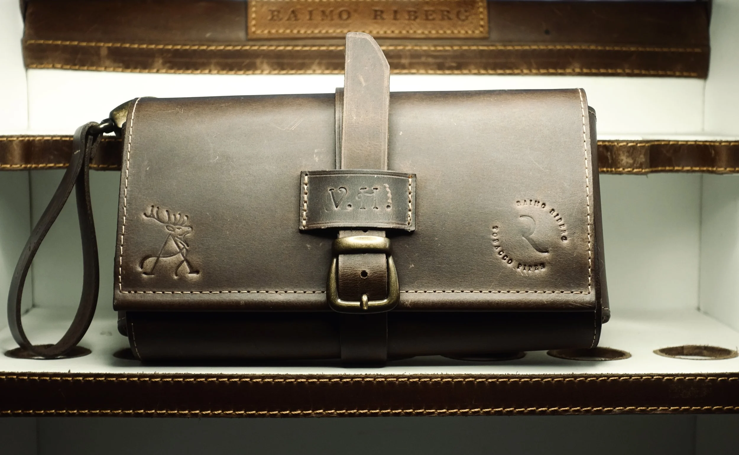 A brown leather chest holster with a strap and buckle, embossed with a small moose and a circular logo reading 'Rocco Pips' along with the words 'Handmade Original.'