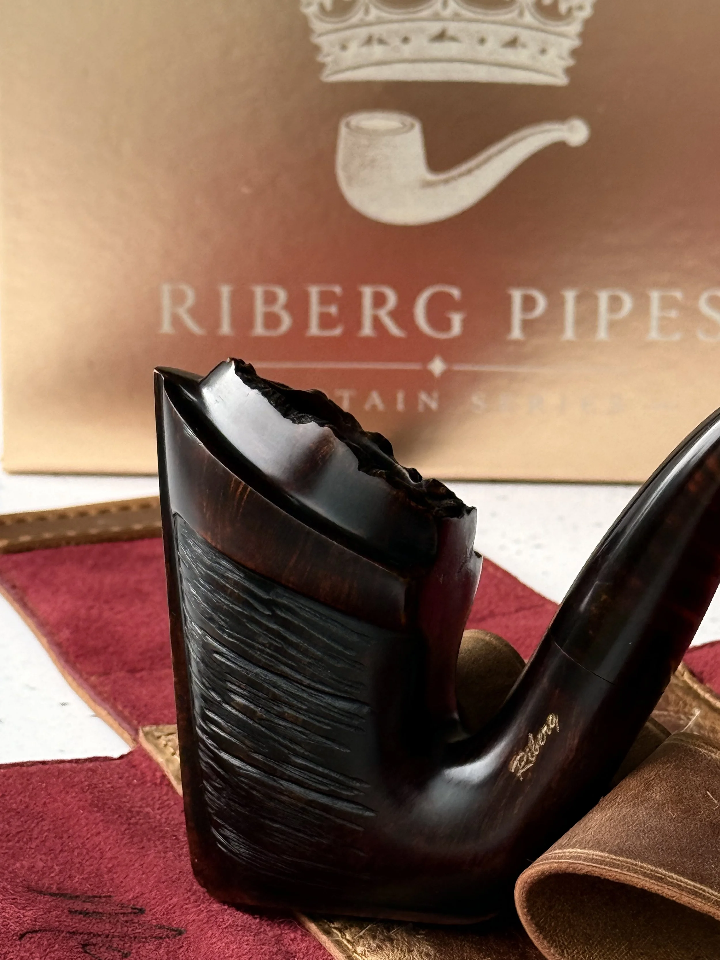 Handgefertigte Tabakpfeife der „Captain Series“ aus Bruyèreholz mit schwarzer, rustikaler Oberfläche und einem bernsteinfarbenen Acrylmundstück von Riberg Pipes.