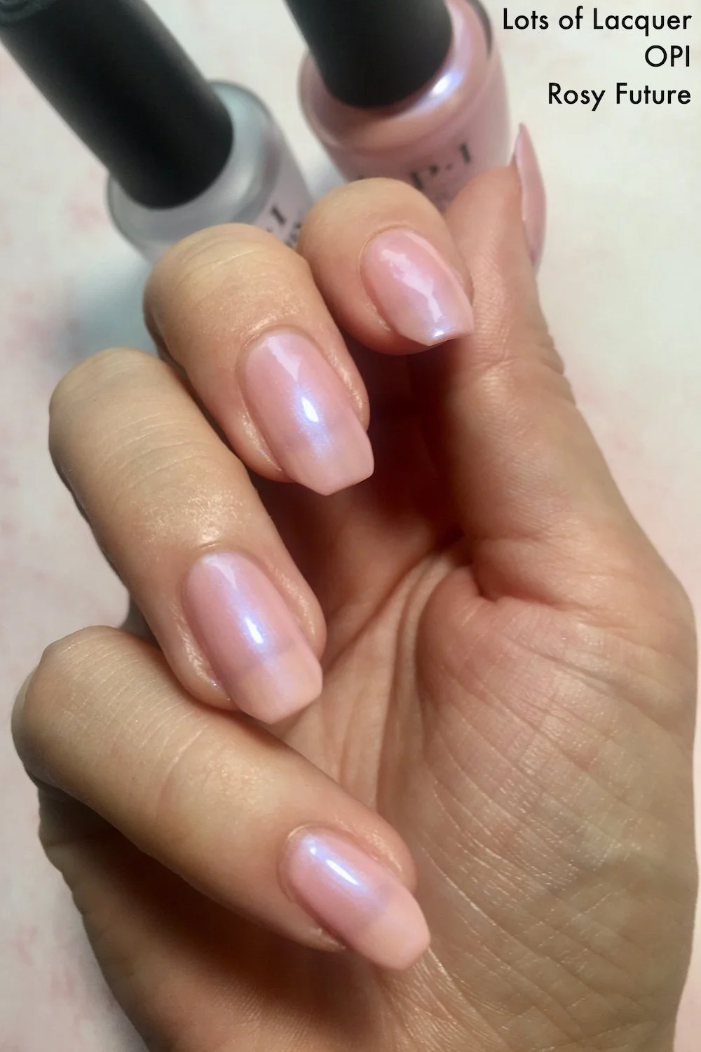 OPI Rosy Future swatch with polish bottles top rear