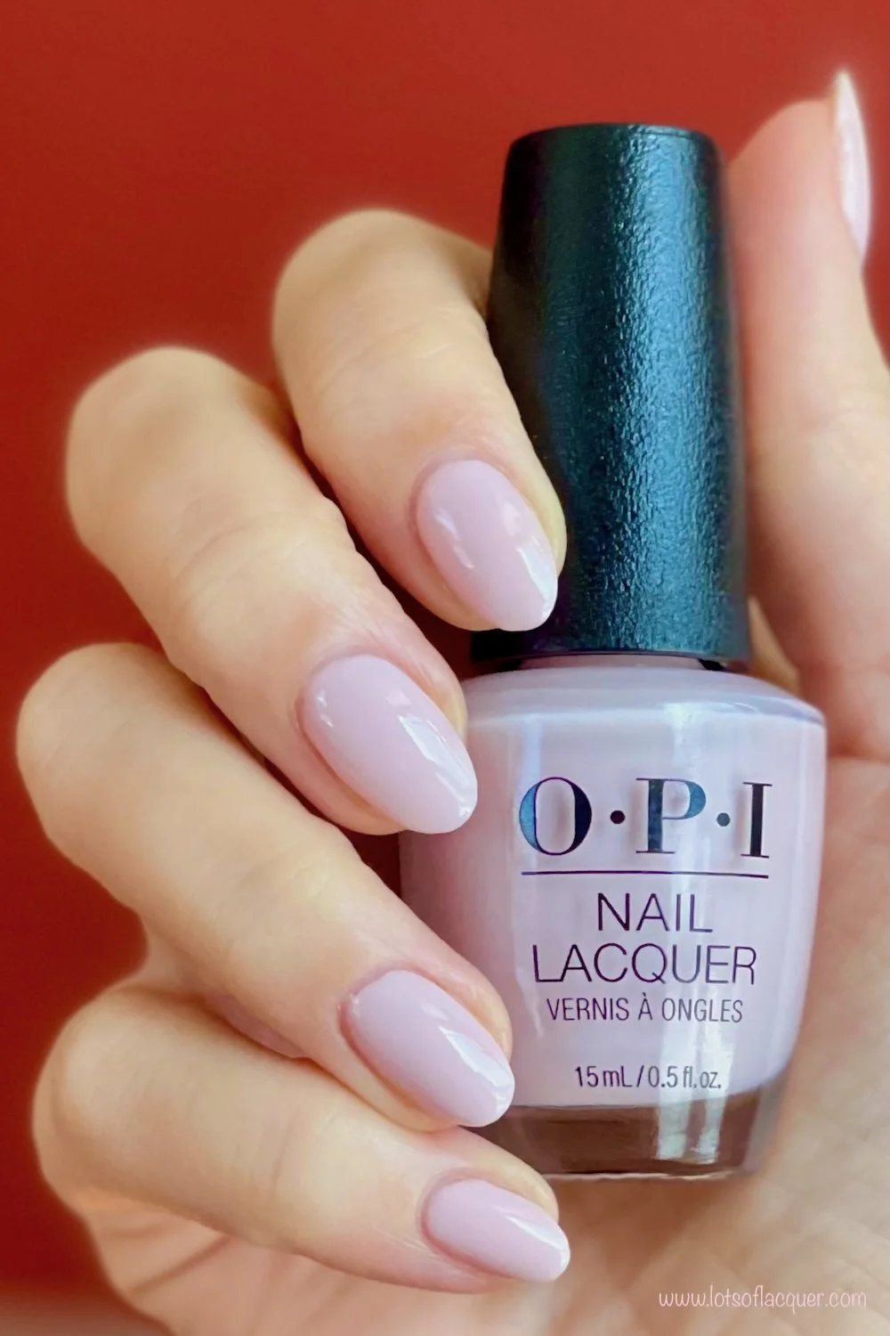 Gifted by Beyond Polish / OPI’m a Bubble Bunny swatch holding bottle with papaya colored background