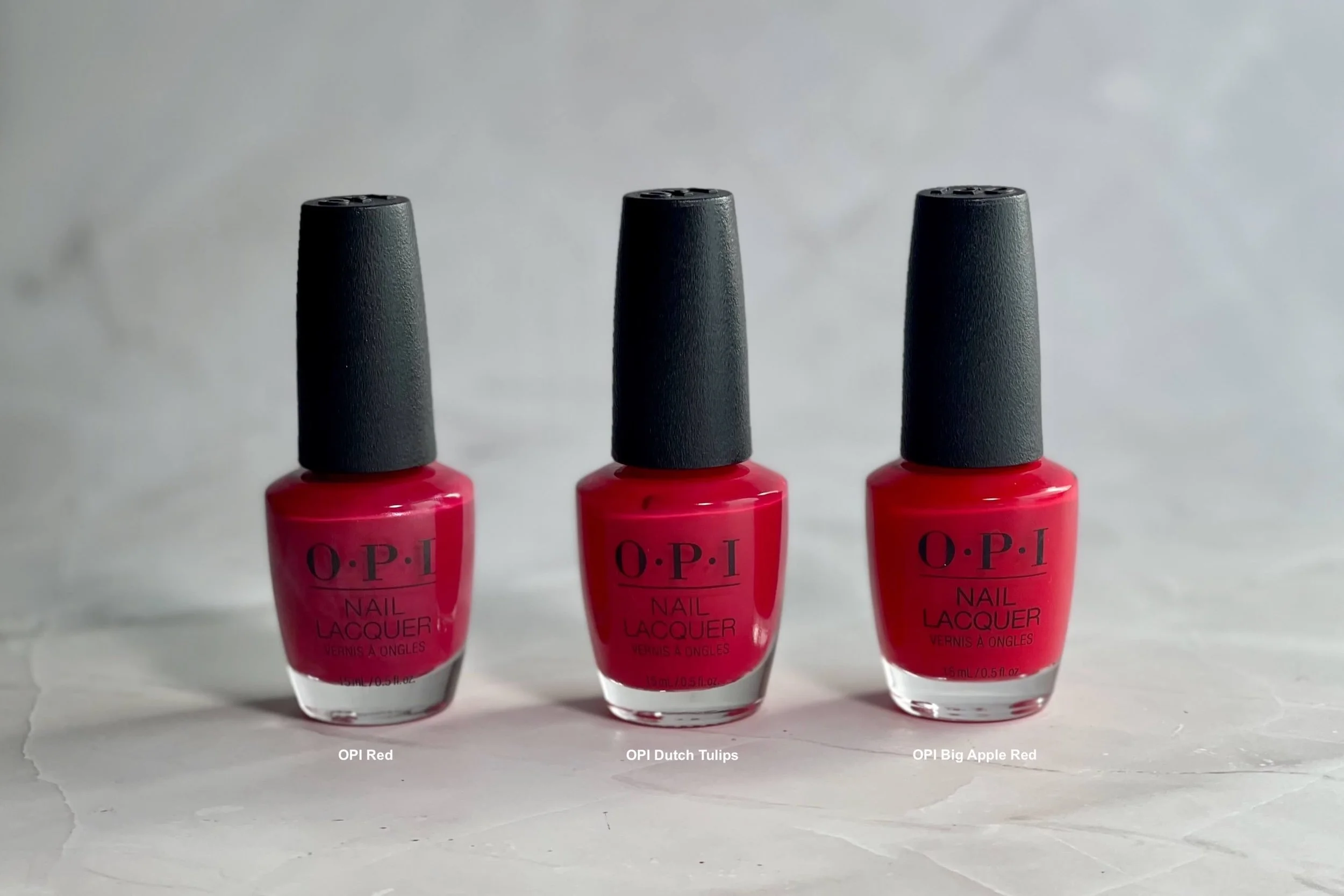 Photo of red nail polish bottles, L to R: OPI Red, Dutch Tulips (zulily gift card), OPI Big Apple Red