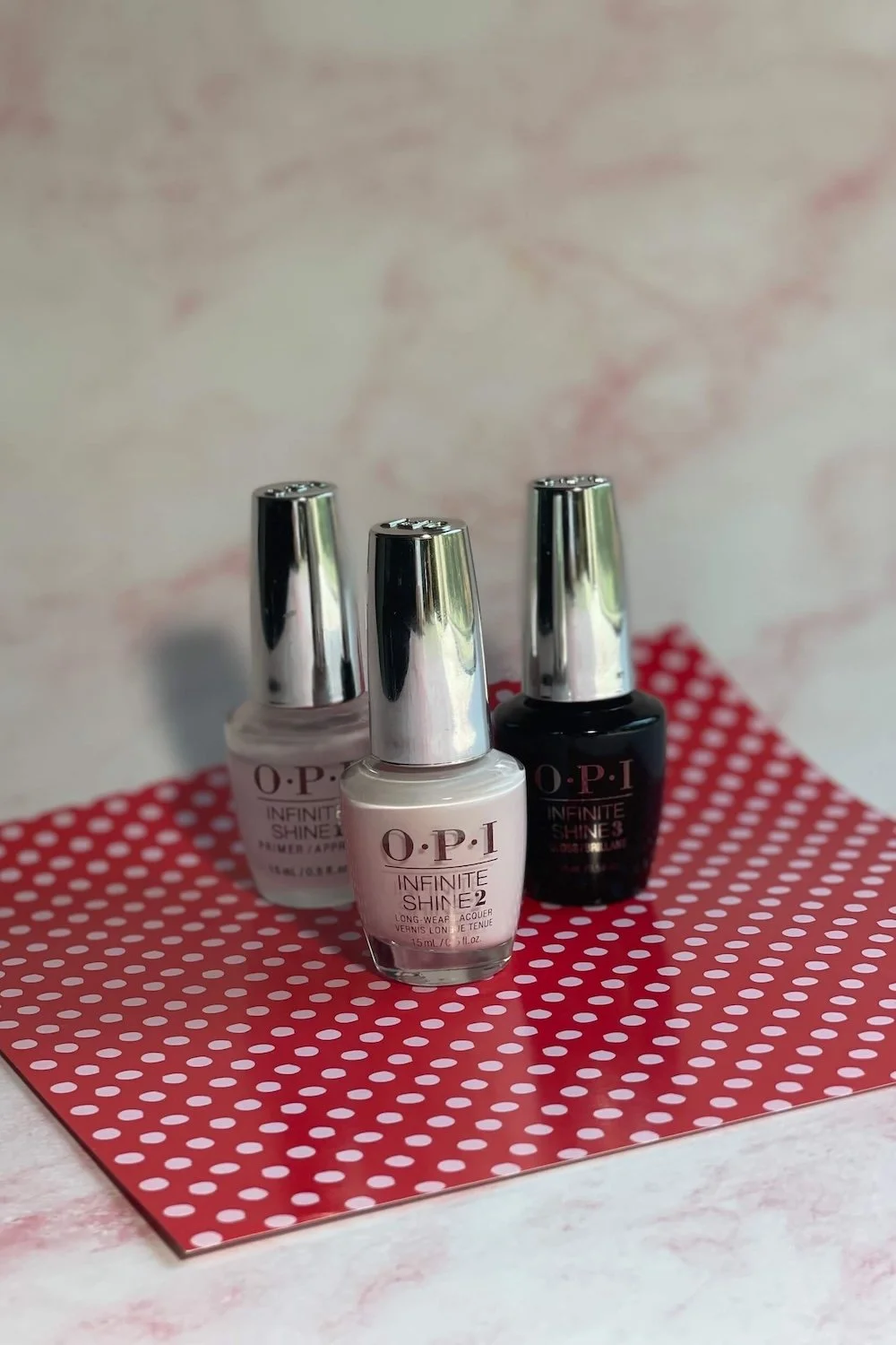 Photo of OPI Infinite Shine Let’s Be Friends! with top and base coat on pink background