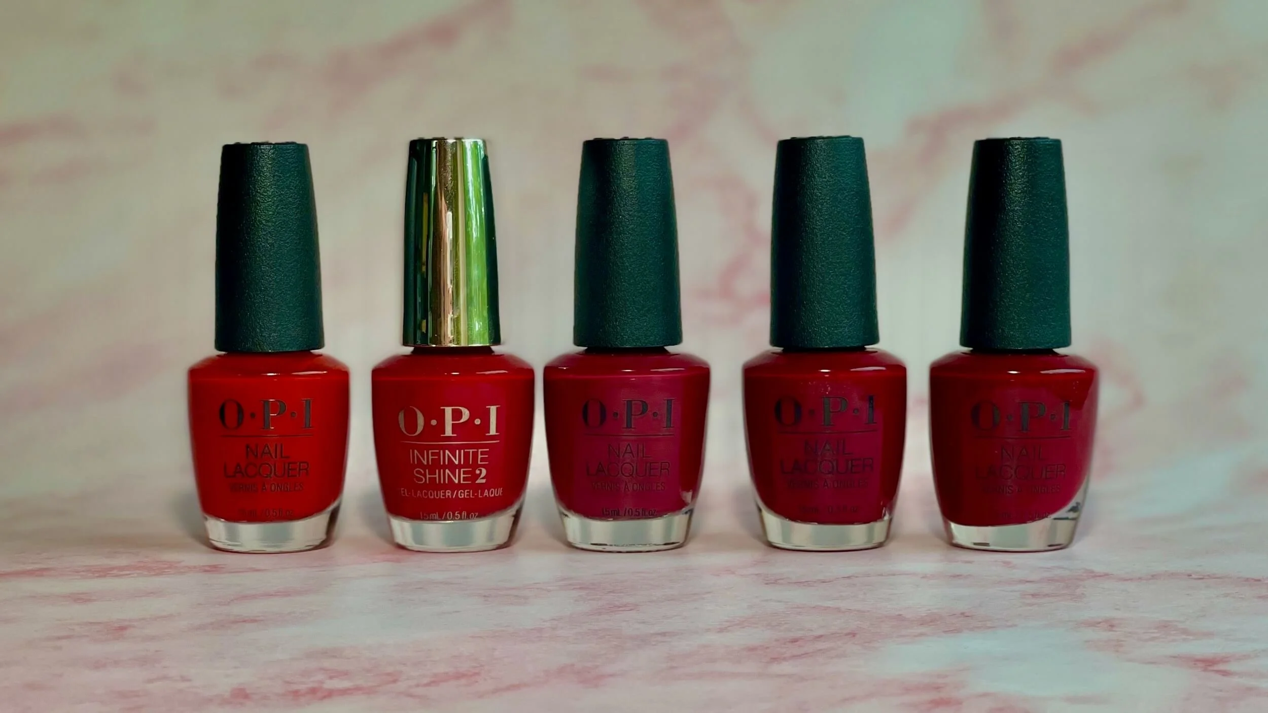 Photo of five OPI red nail polish bottles - Art Walk in Suzi’s Shoes, Thrill of Brazil, We the Female, Malaga Wine, Got the Blues for Red